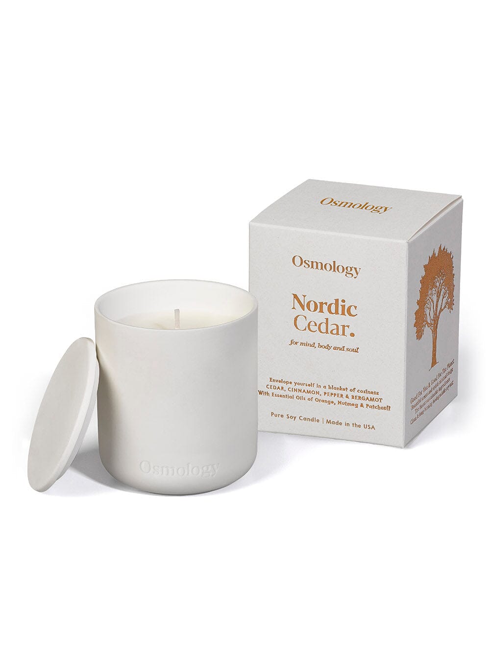 Osmology Nordic Cedar white ceramic candle displayed next to box packaging