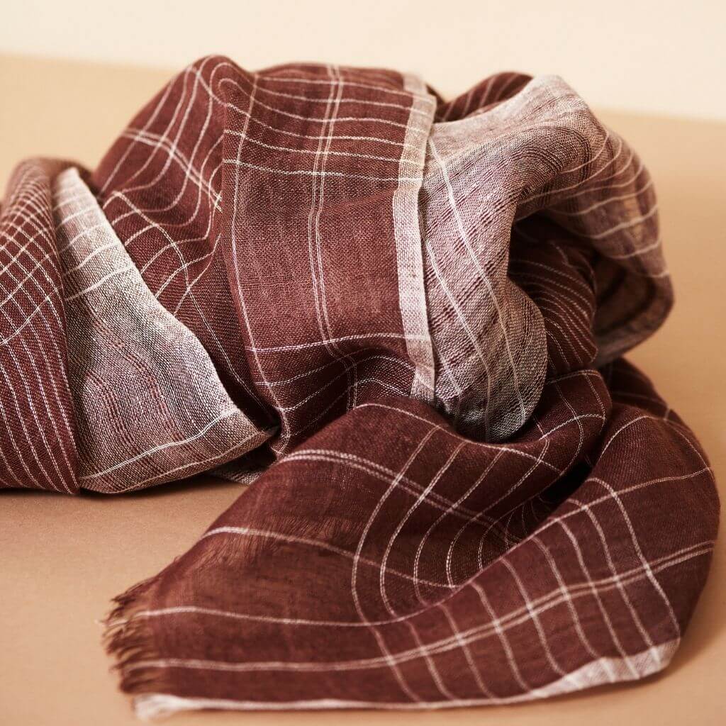 Auro Cinnabar Handwoven Earthy Rust Maroon Linen Scarf displayed elegantly with textured fabric folds.