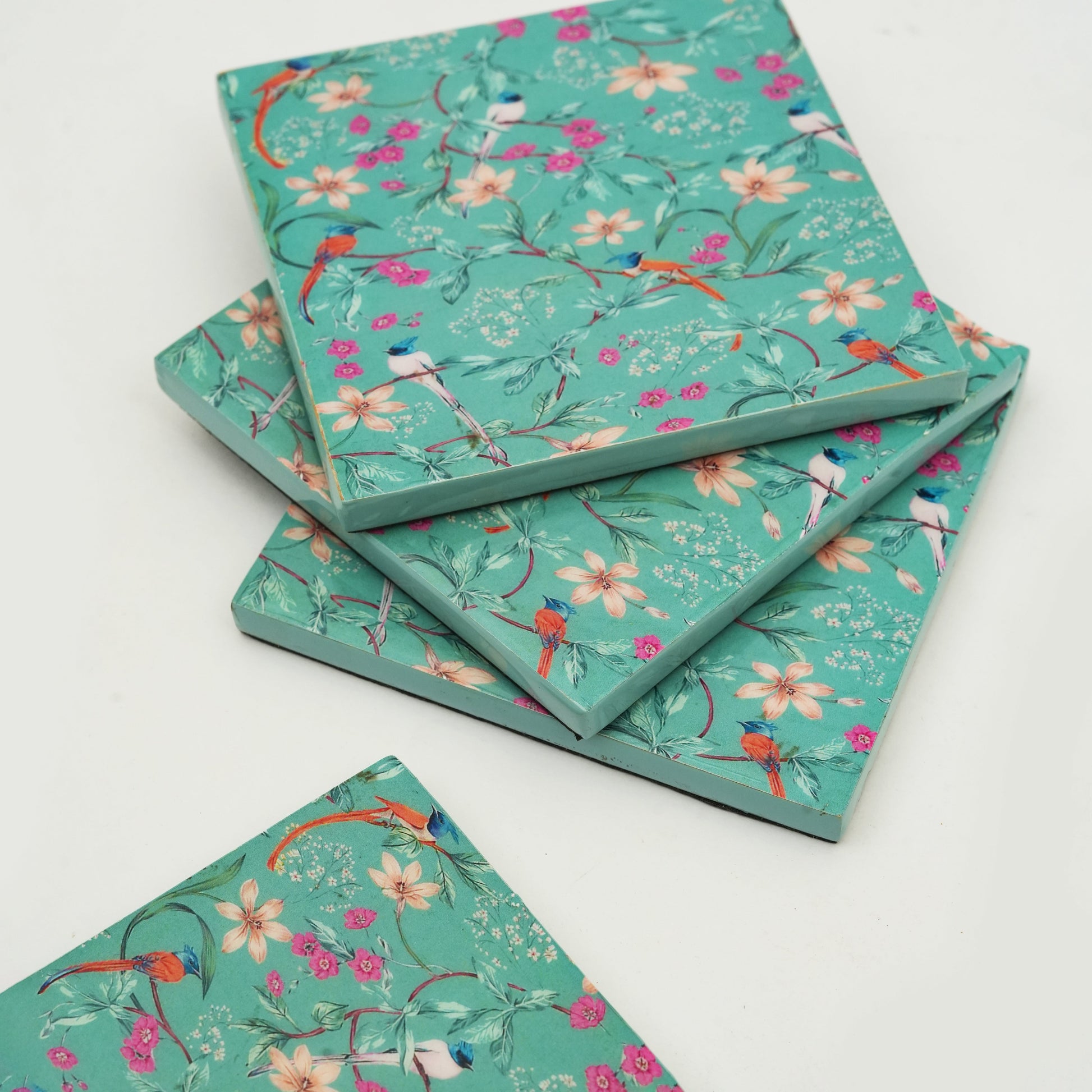 Stack of notebooks with floral and bird pattern on a white background
