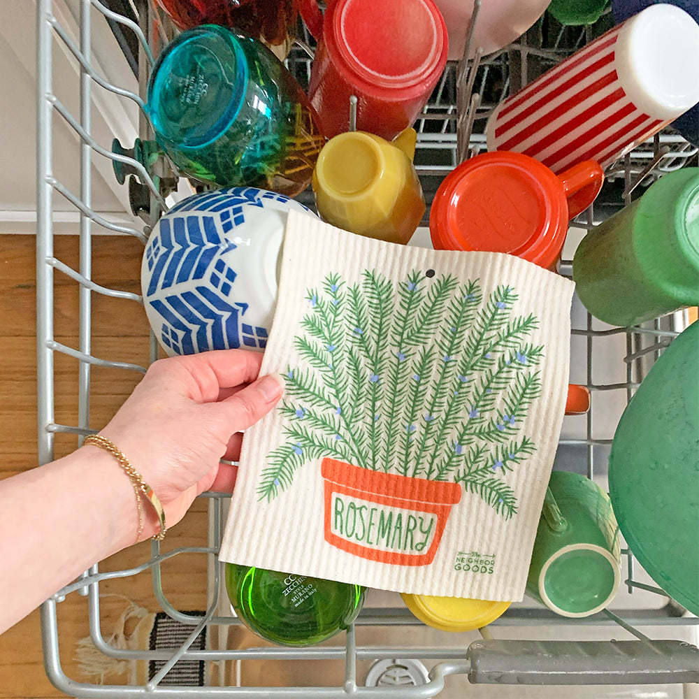 A woman places the Rosemary sponge cloth on the top rack of the dishwasher.