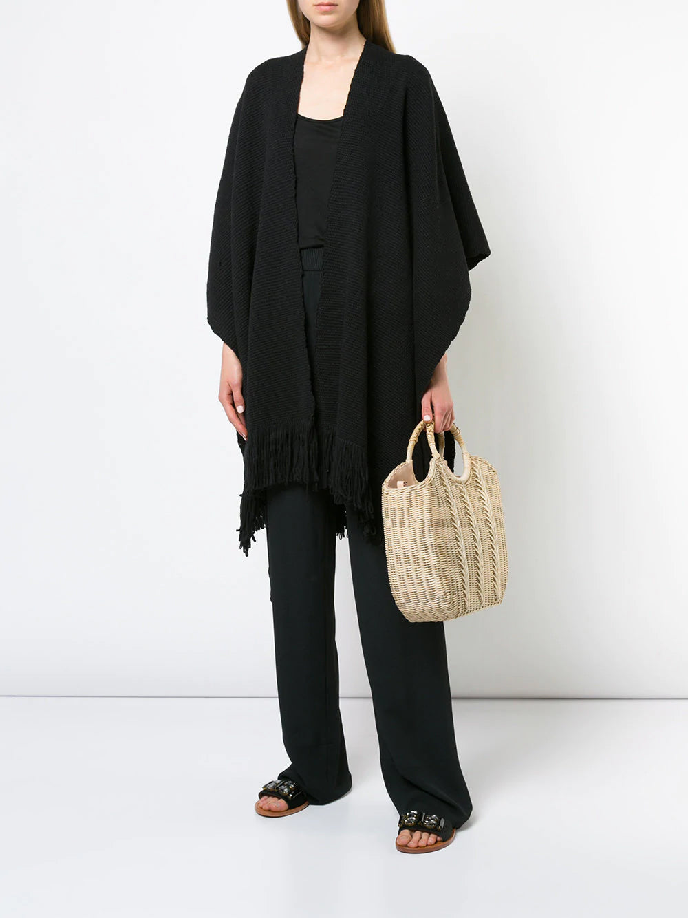 Model wearing a black Cotton Duna Fringe Duster with a woven bag