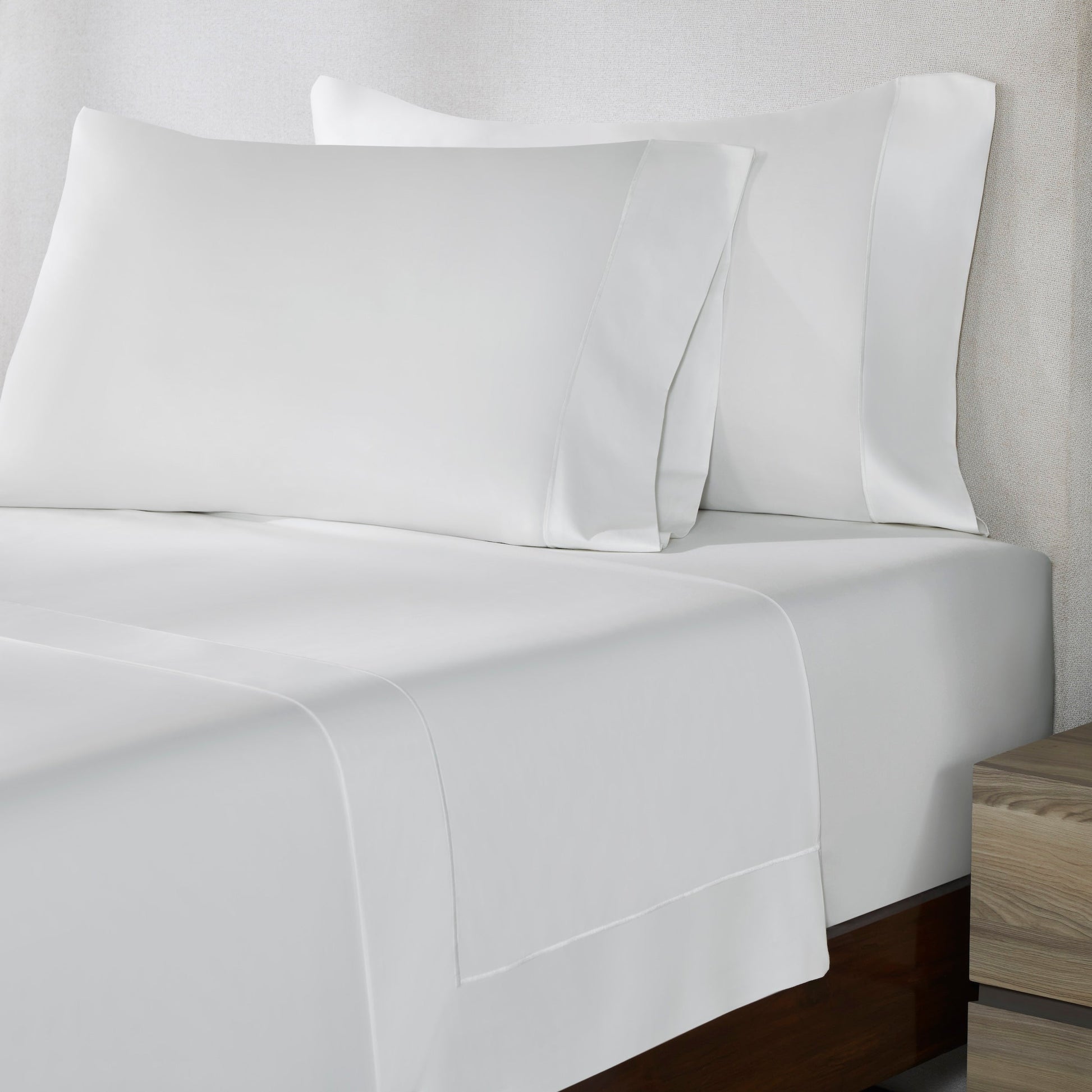 CFT-534-7284_3|Close-up of a plain white 100% cotton sheet set on a bed. Displays a flat sheet and two matching pillowcases.