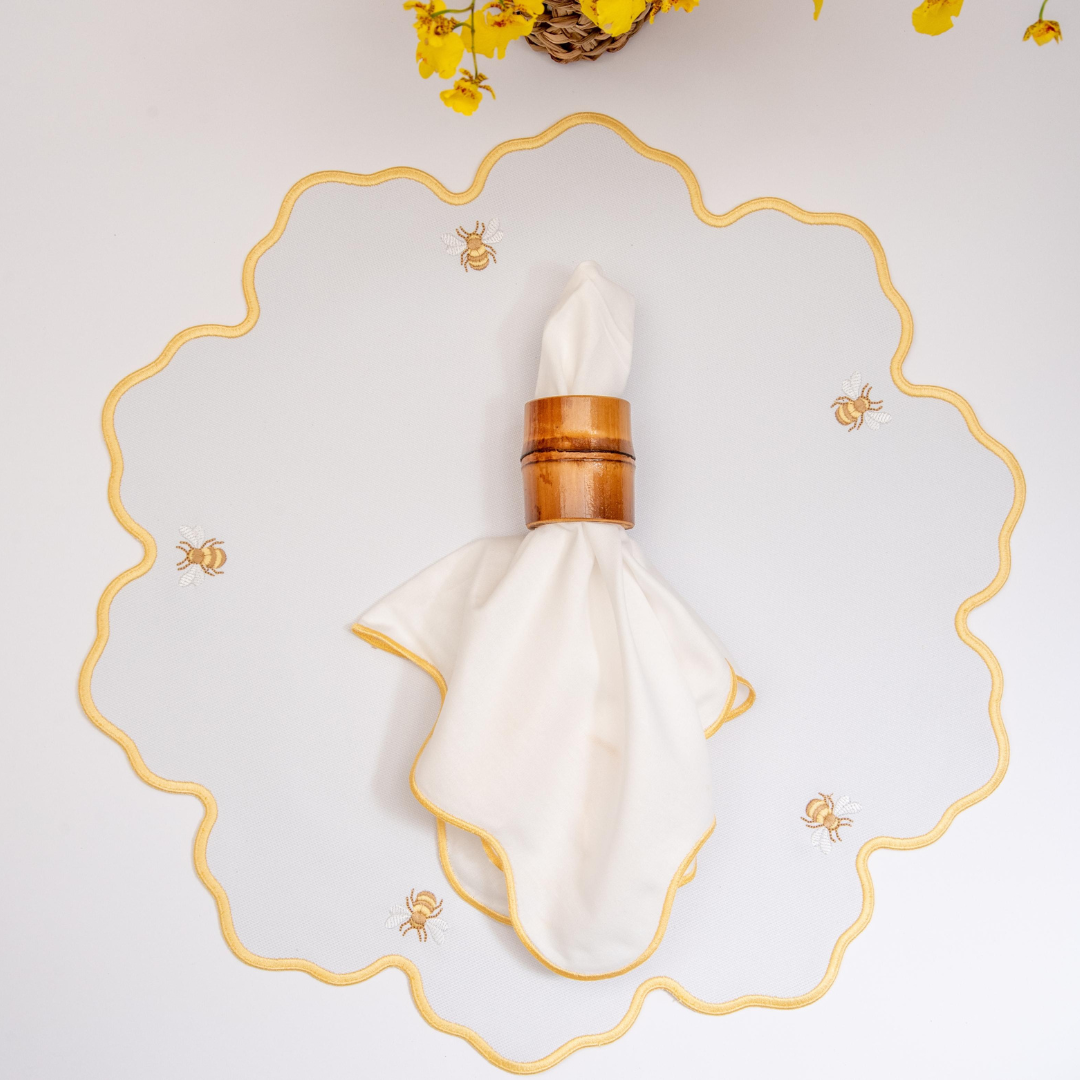 Bumble bee impermeable placemat with hand-stitched bee embroidery and yellow wavy border by Talah Home