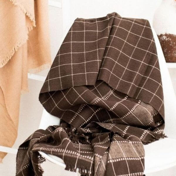 Treacle Checks Pattern Organic Cotton Handloom Throw draped on a chair showcasing its luxurious checked design.