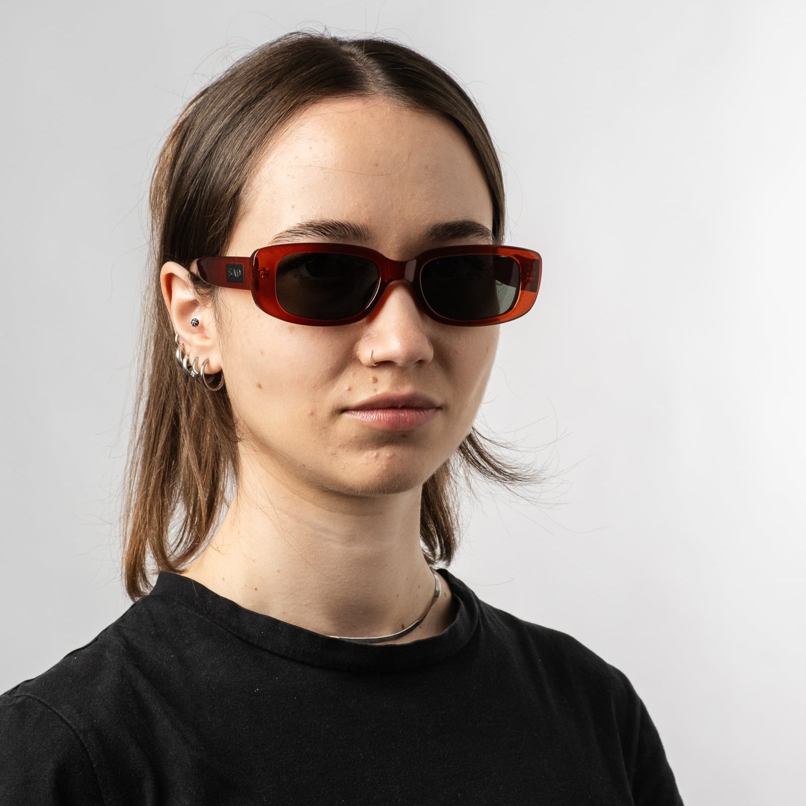 Female wearing Sad Eyewear Bouquet rectangle sunglasses in blood red with black tinted lenses