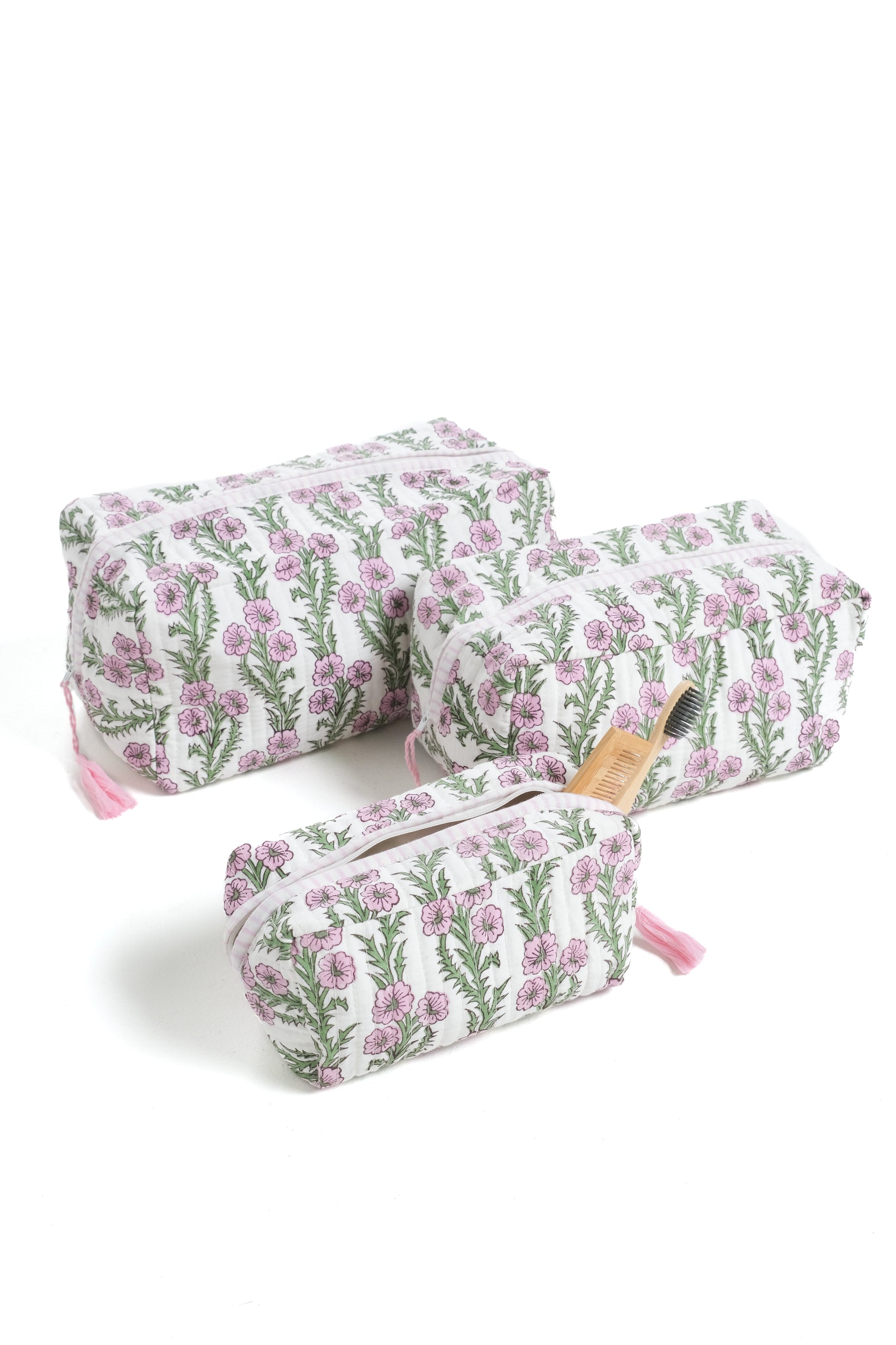 Lilac pink blockprint makeup bags with forget-me-not floral pattern, pink tassels, holding bamboo accessories