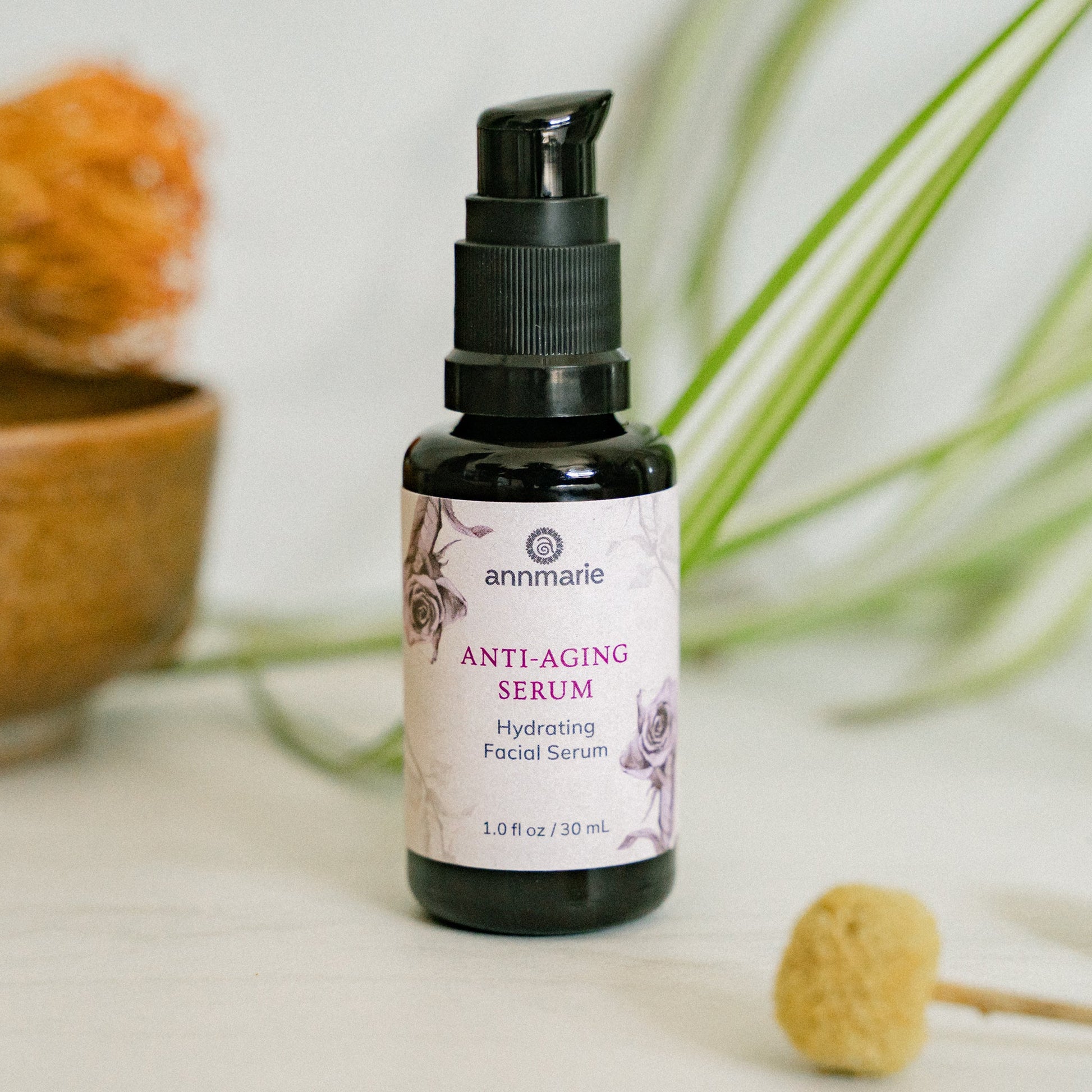 Anti-Aging Serum hydrating facial serum 30 ml pump bottle with botanical packaging displayed with greenery for natural skincare product styling.
