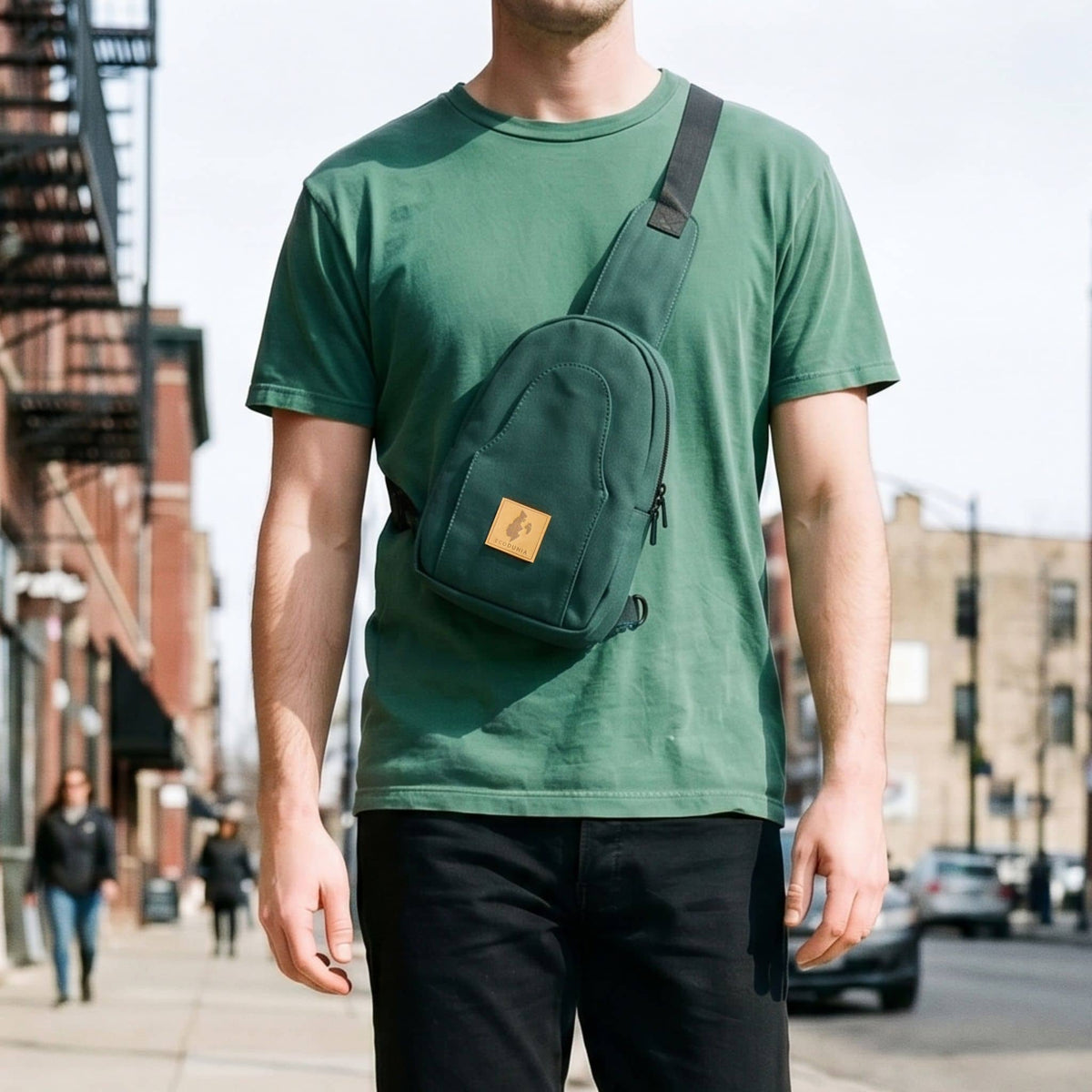 Buru canvas sling bag in forest green worn crossbody #color_forest-green