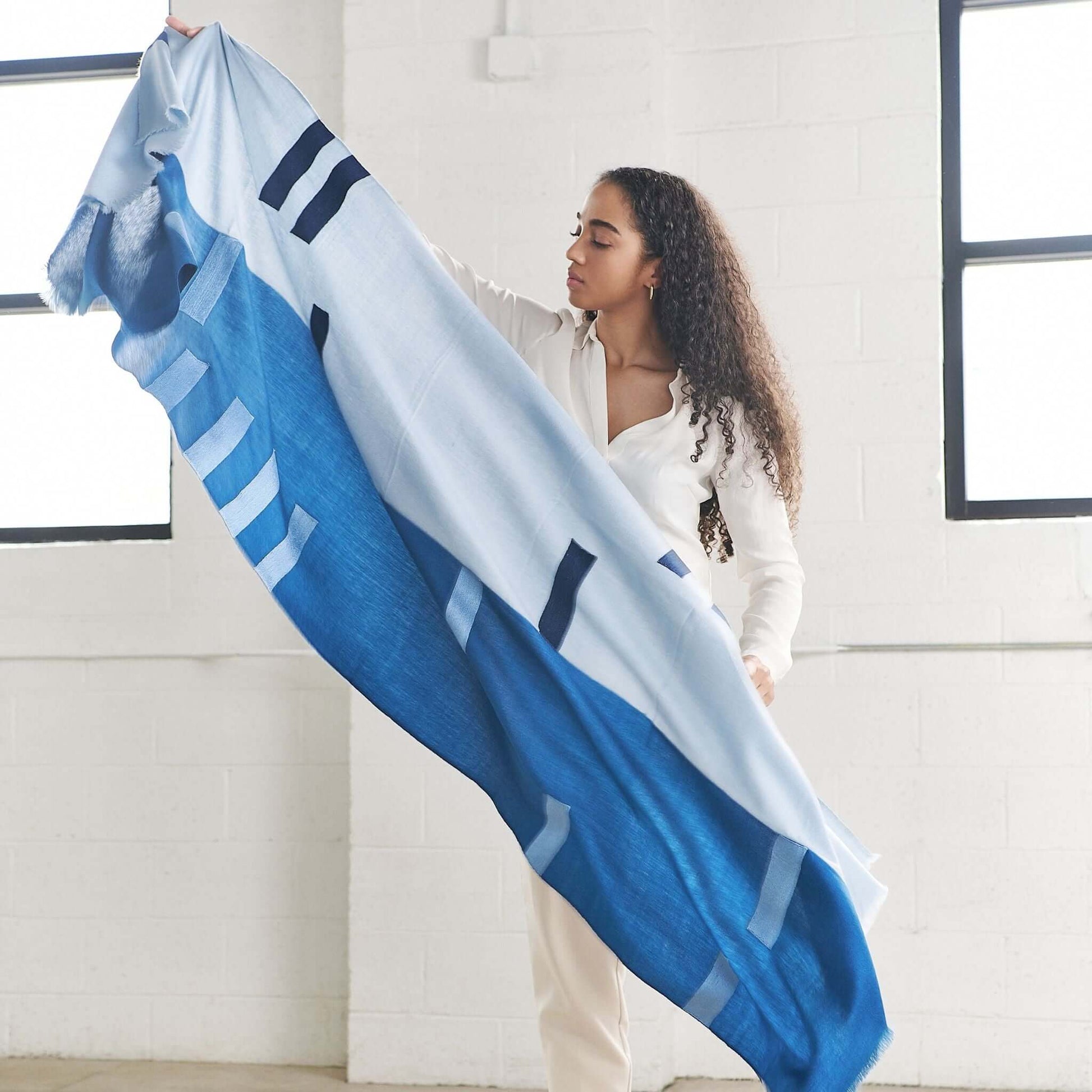 Harbor Blue Silk Merino Hand Woven Hand Embroidered Modern Artisanal Scarf displayed by model in bright indoor setting.