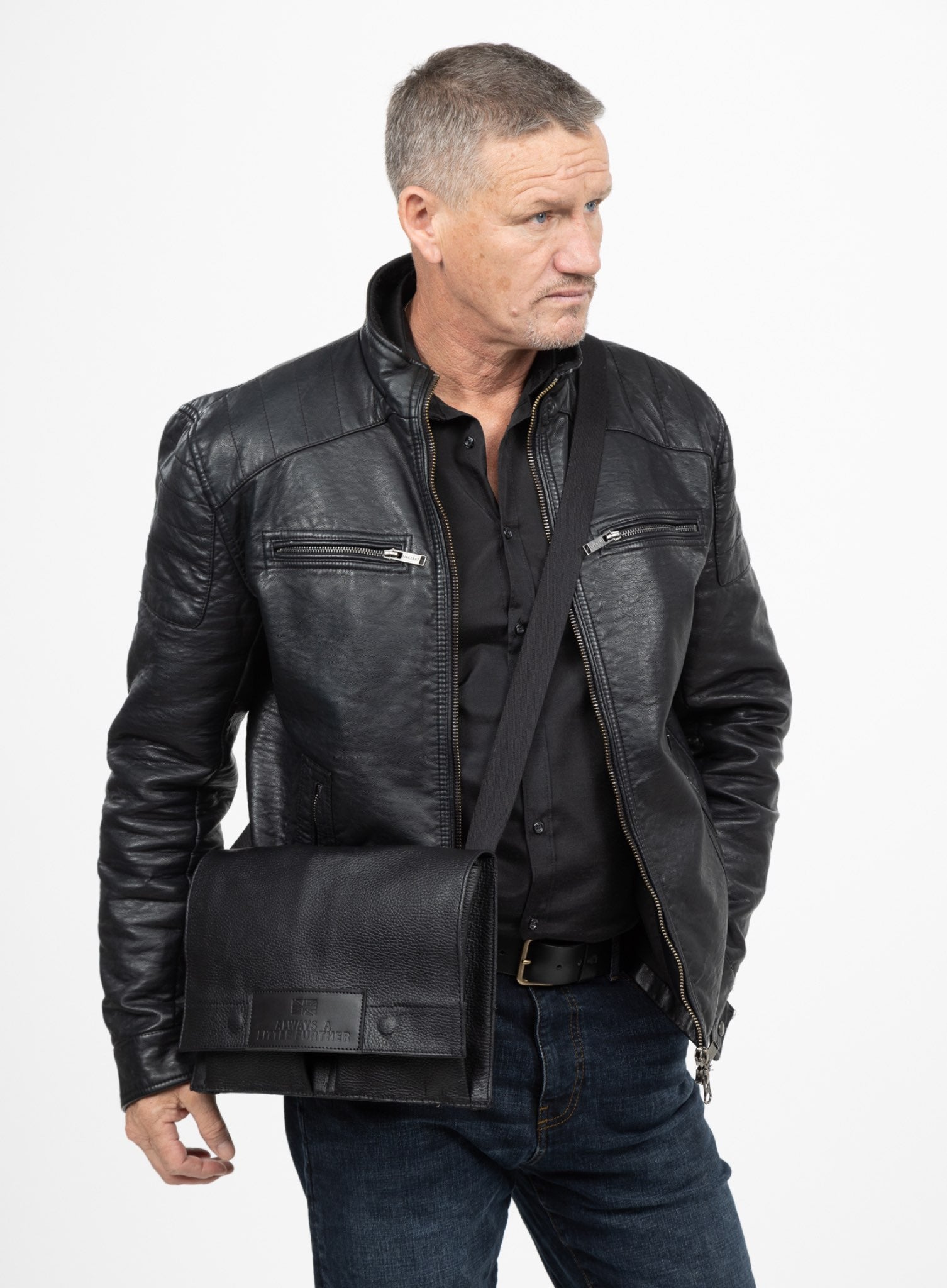 Man in leather jacket with black claymore bag, side view