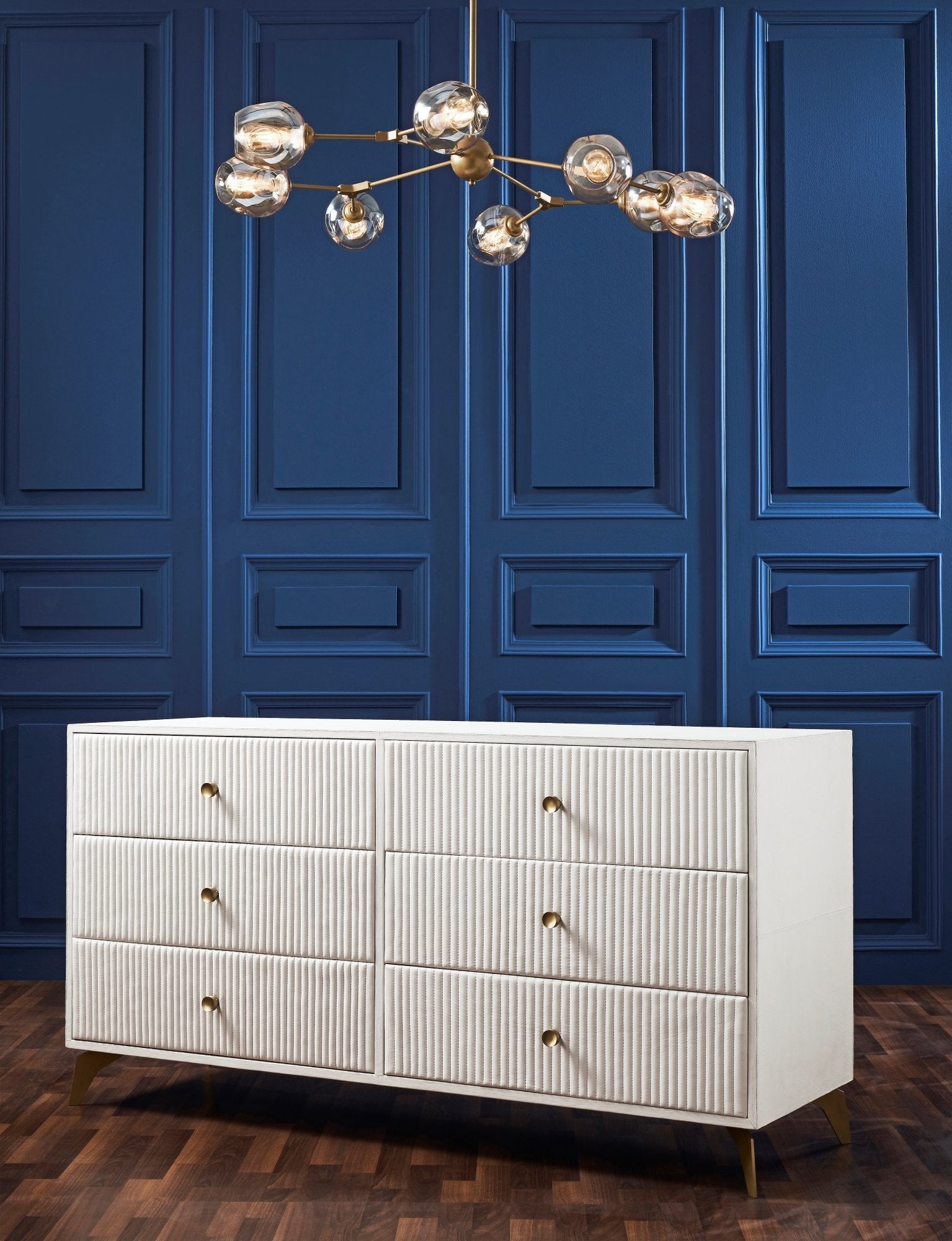 FN-5203-642033_6|White leather six-drawer dresser with ridged texture and gold pulls in a room with blue paneled walls, luxury furniture.