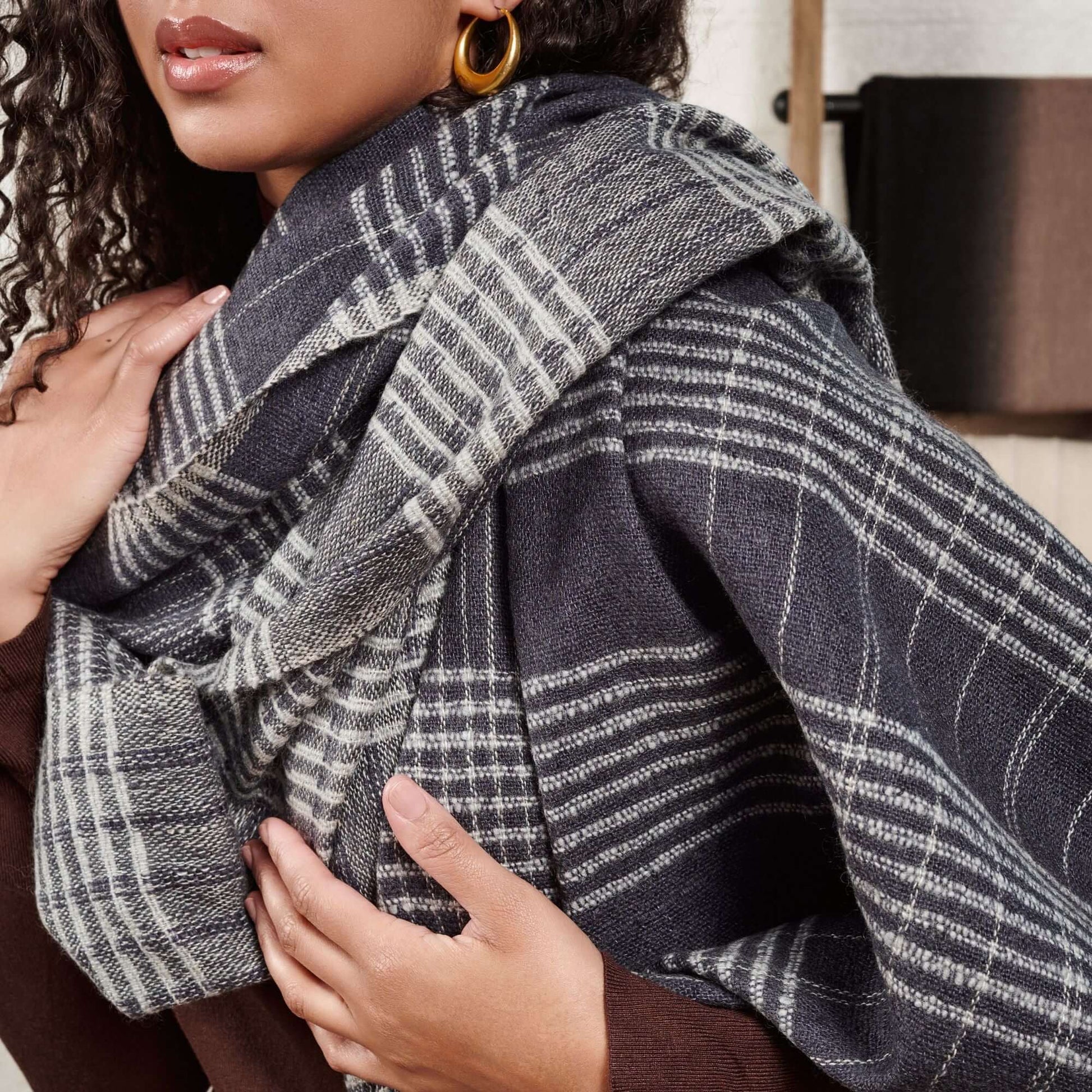 Alloy Dark Blue Stripes Pattern Soft Merino Linen Handloom Throw styled on a model's shoulders showcasing its elegant design.