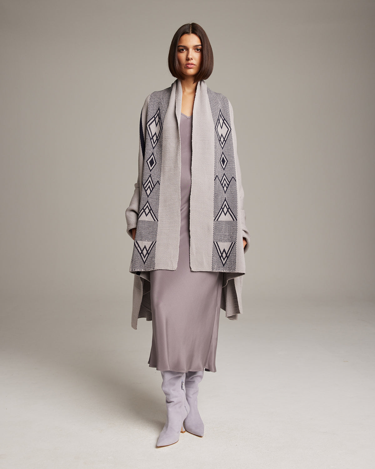 Model wearing a Wide Diagonal Alpaca Wrap with geometric patterns in grey and ivory.