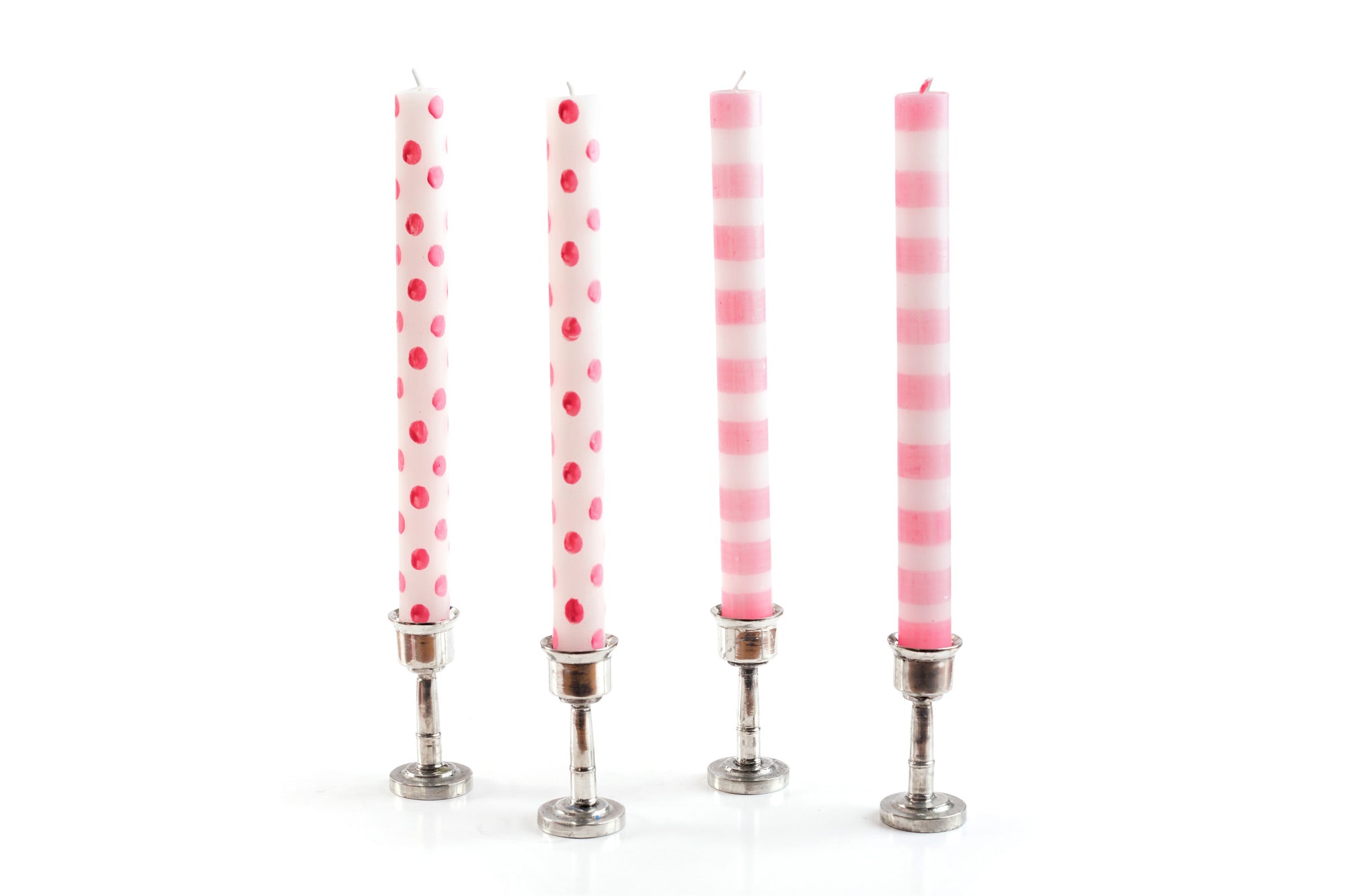 4 taper candles in pewter taper candle holders.  Two white taper candles with pink dots, and two white taper candles with pink stripes.