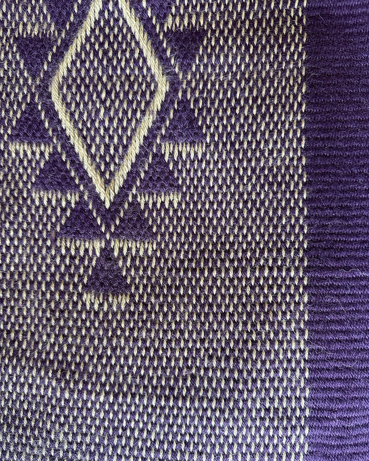 Close-up of Estrella Shawl featuring a diamond pattern in purple and cream.