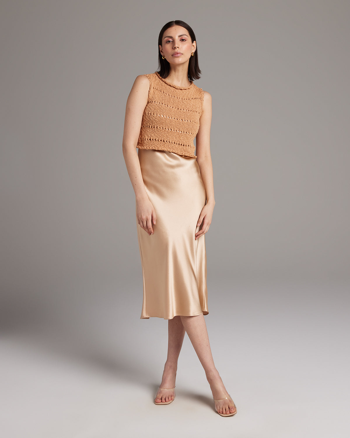 Model wearing apricot Flammé Knit Crop Top with a satin skirt