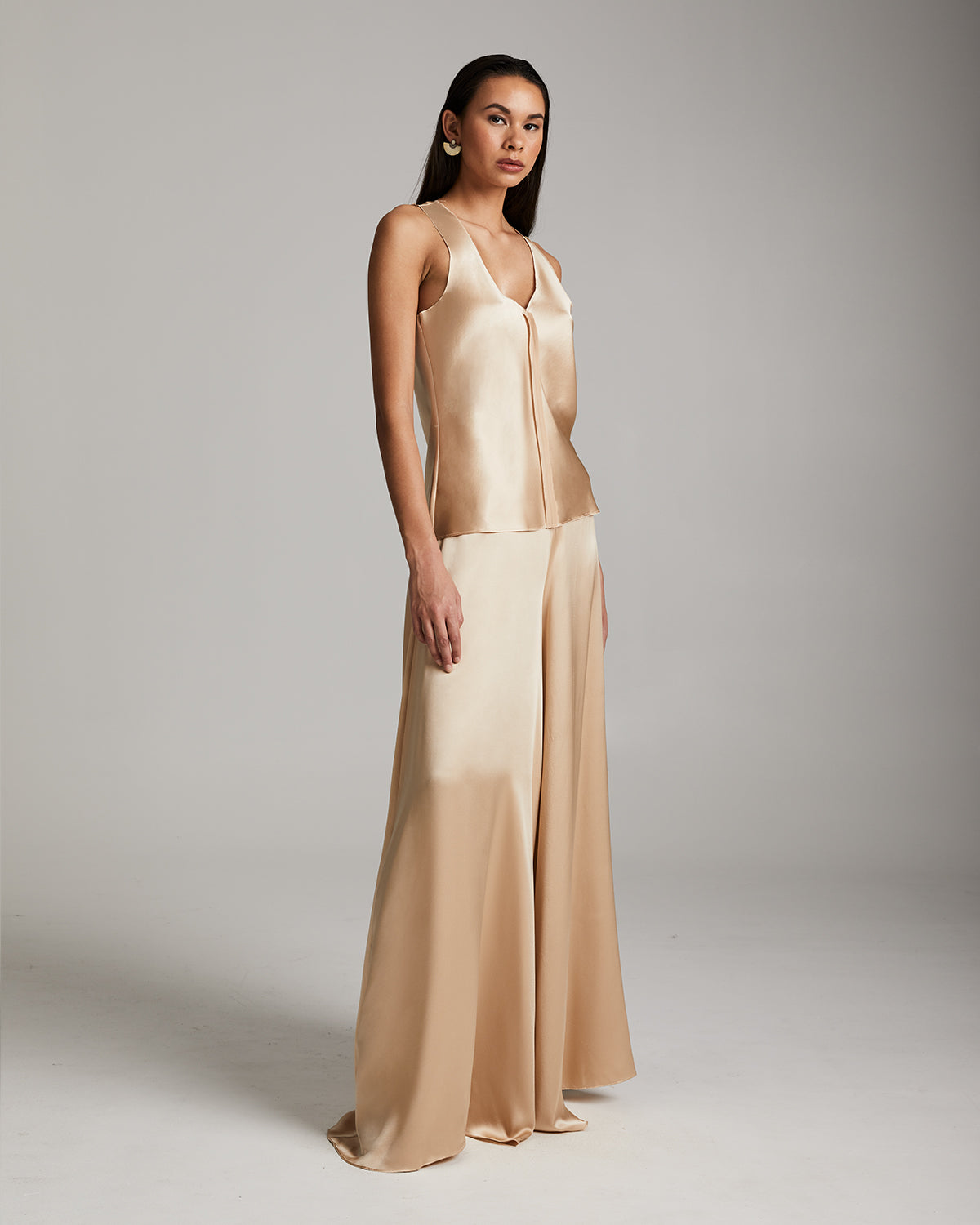 Model wearing a silk palazzo pants and tank top in blush color