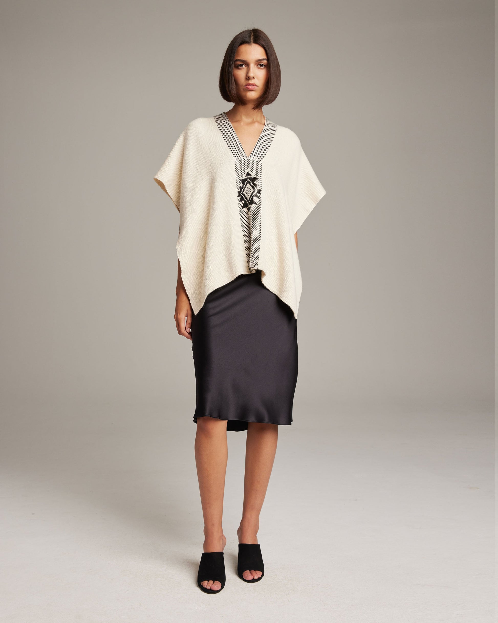 Model wearing Manta Estrella in Cotton poncho over a black dress