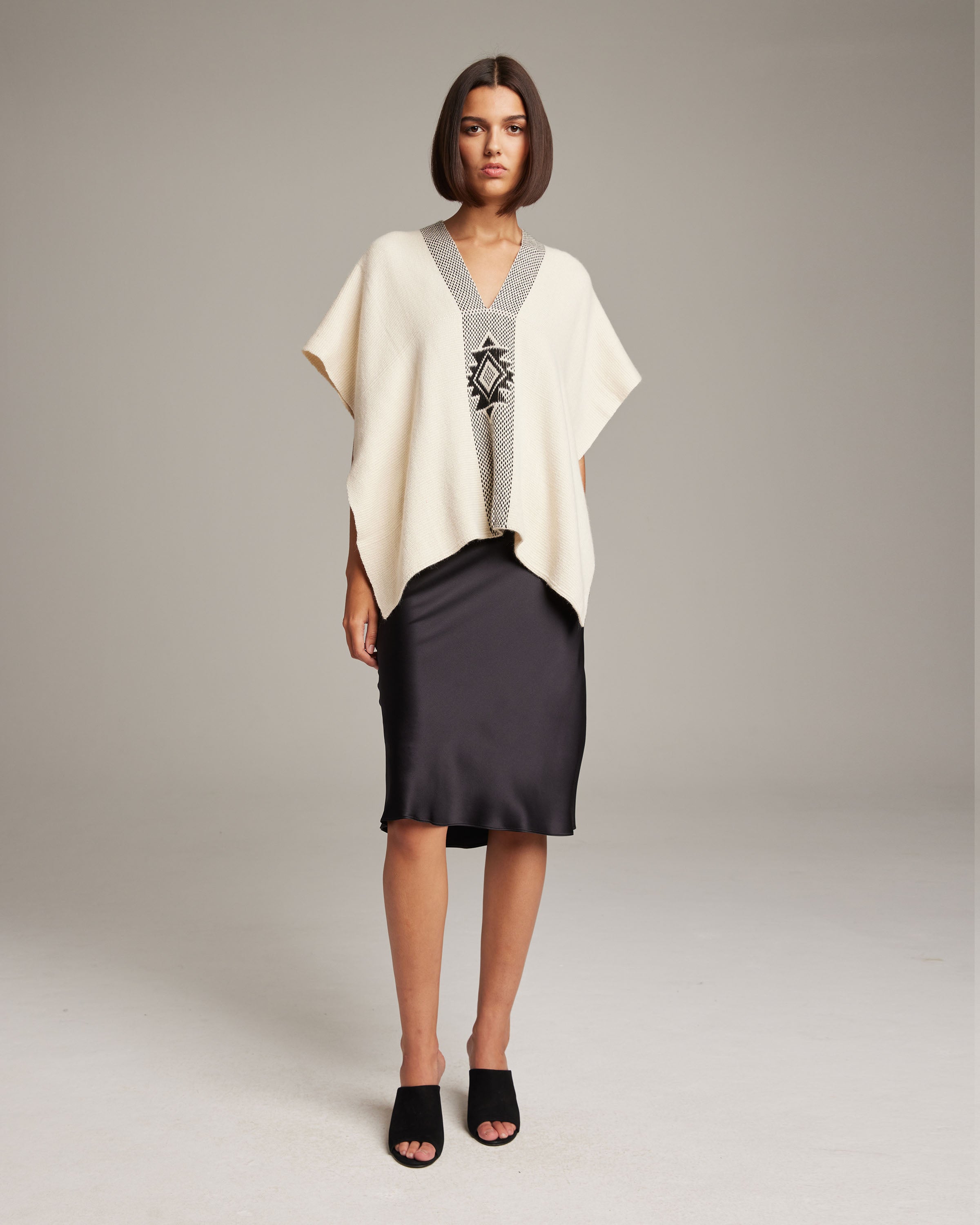 Model wearing Manta Estrella in Cotton poncho over a black dress