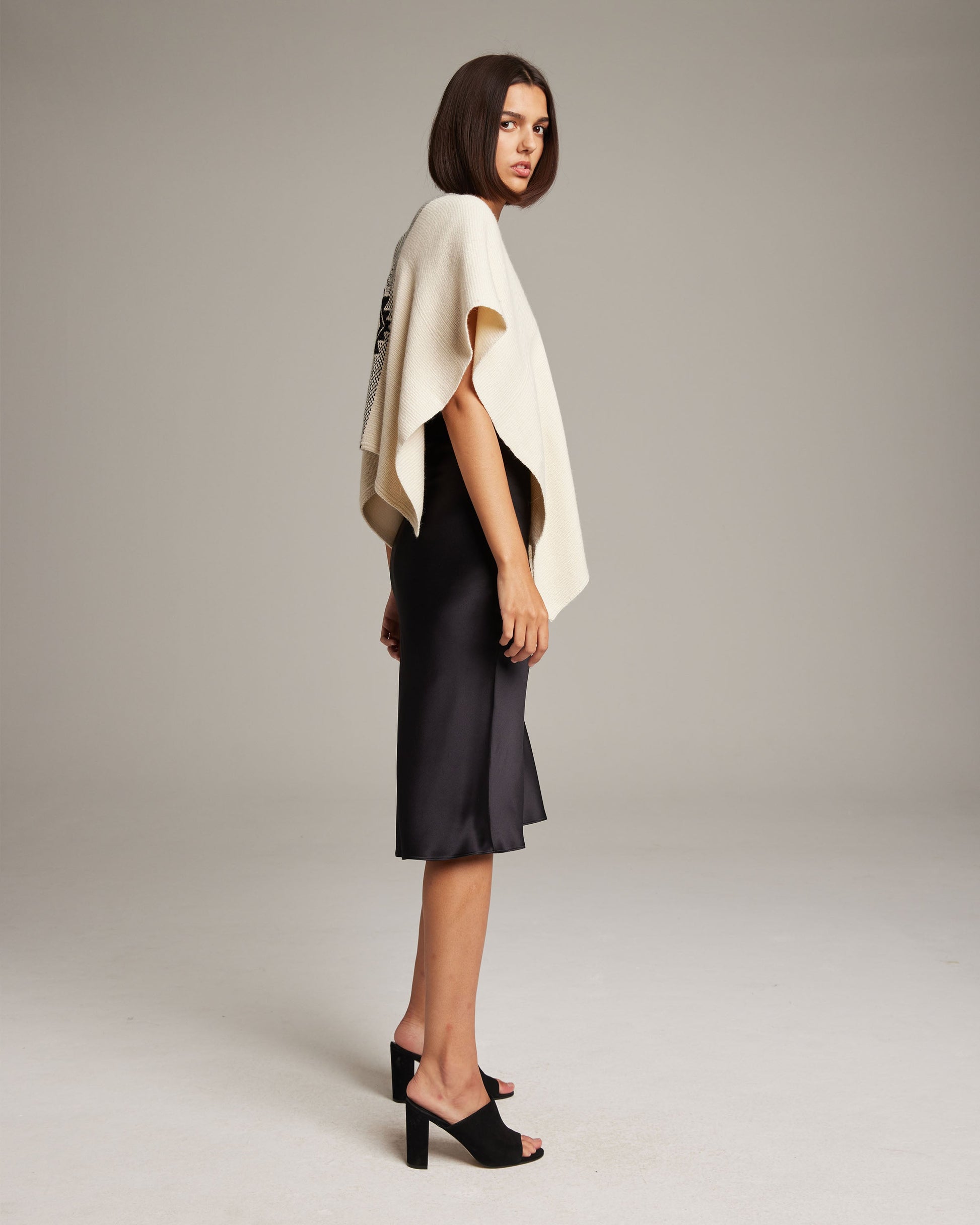 Model wearing Manta Estrella poncho in ivory, showcasing the Estrella pattern.
