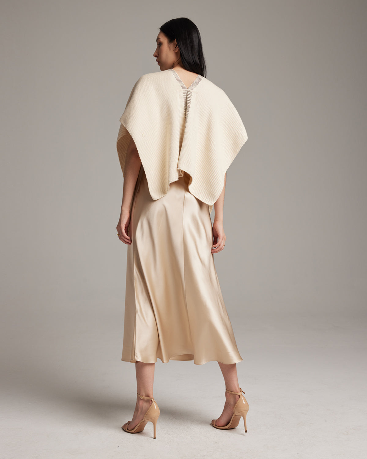 Model wearing a handwoven ivory poncho from the back