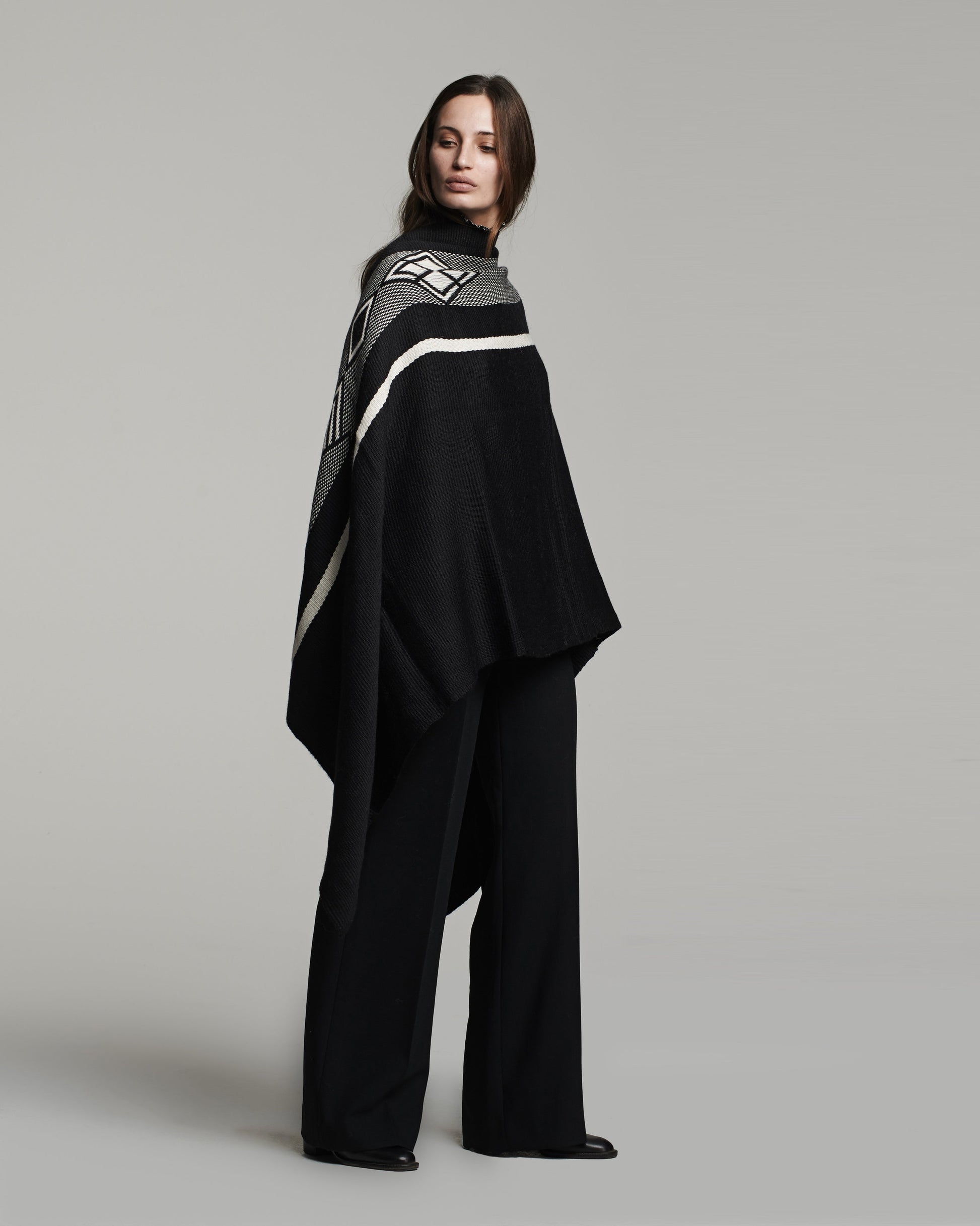 Model wearing a black and white Wide Diagonal Alpaca Wrap, showcasing its design.
