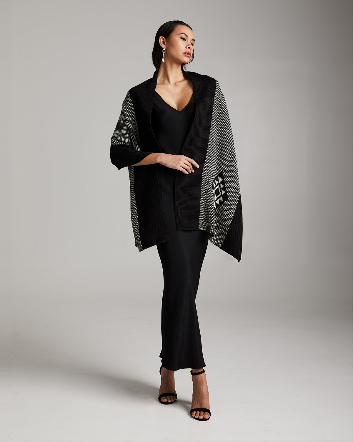Model wearing the Estrella Shawl in black and grey, standing against a neutral background.