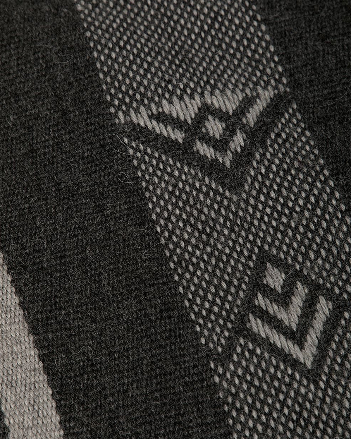 Close-up of the Wide Diagonal Alpaca Wrap fabric showing intricate patterns in grey and black.
