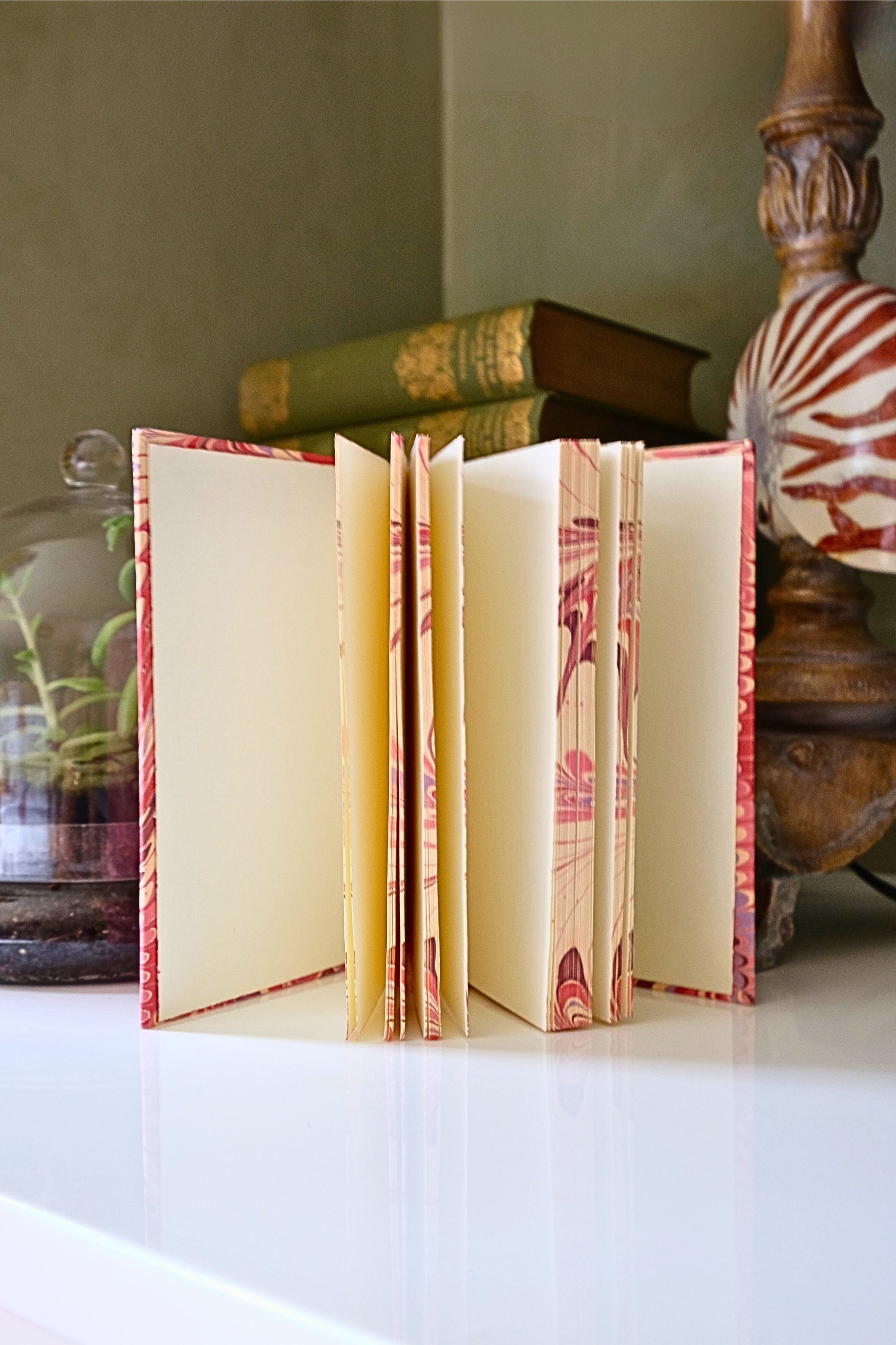 Open hand-marbled hardcover notebook in florentine pink