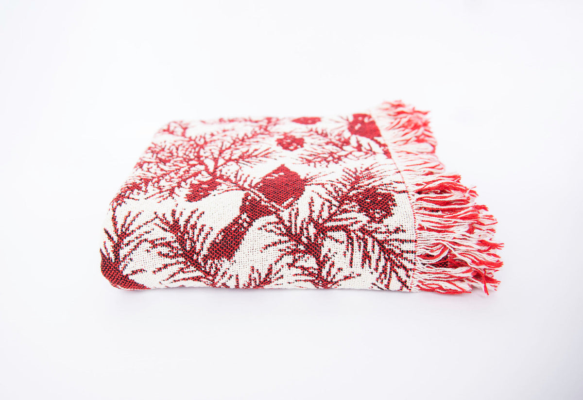 Side view of folded cranberry red and cream cardinal woven cotton throw with fringe