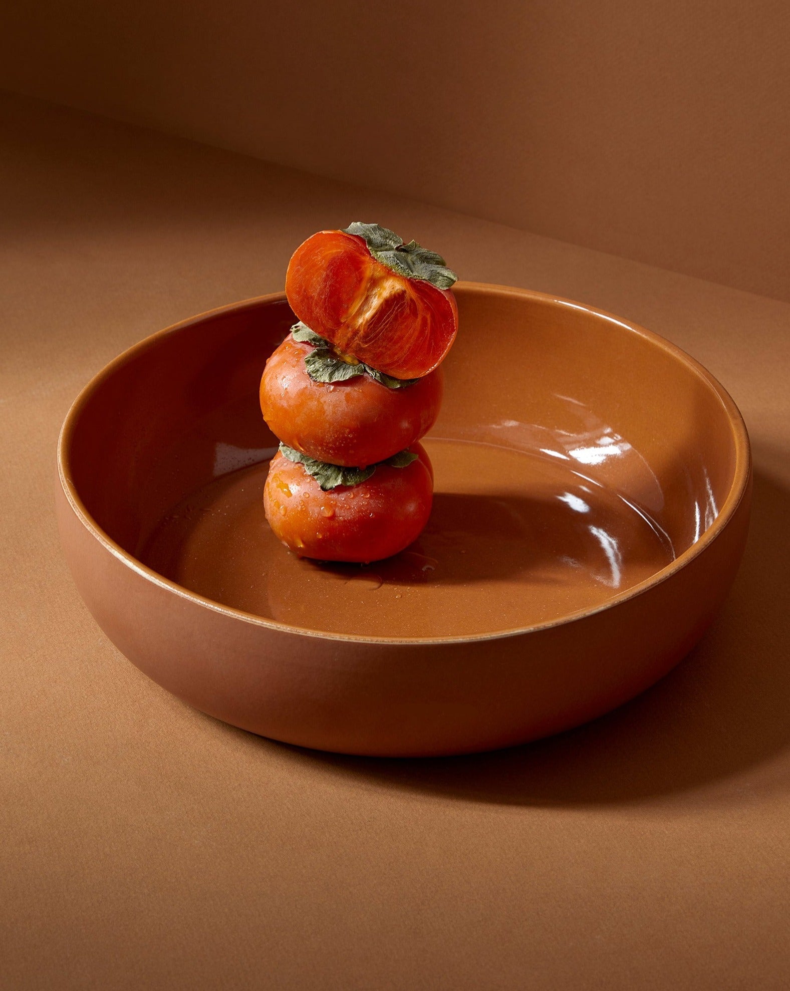 A beige Stoneware Shallow Serving Bowl with a capacity of 60 oz, displayed against a neutral background with a small amount of food items like pasta or noodles in it to showcase its size and shape.