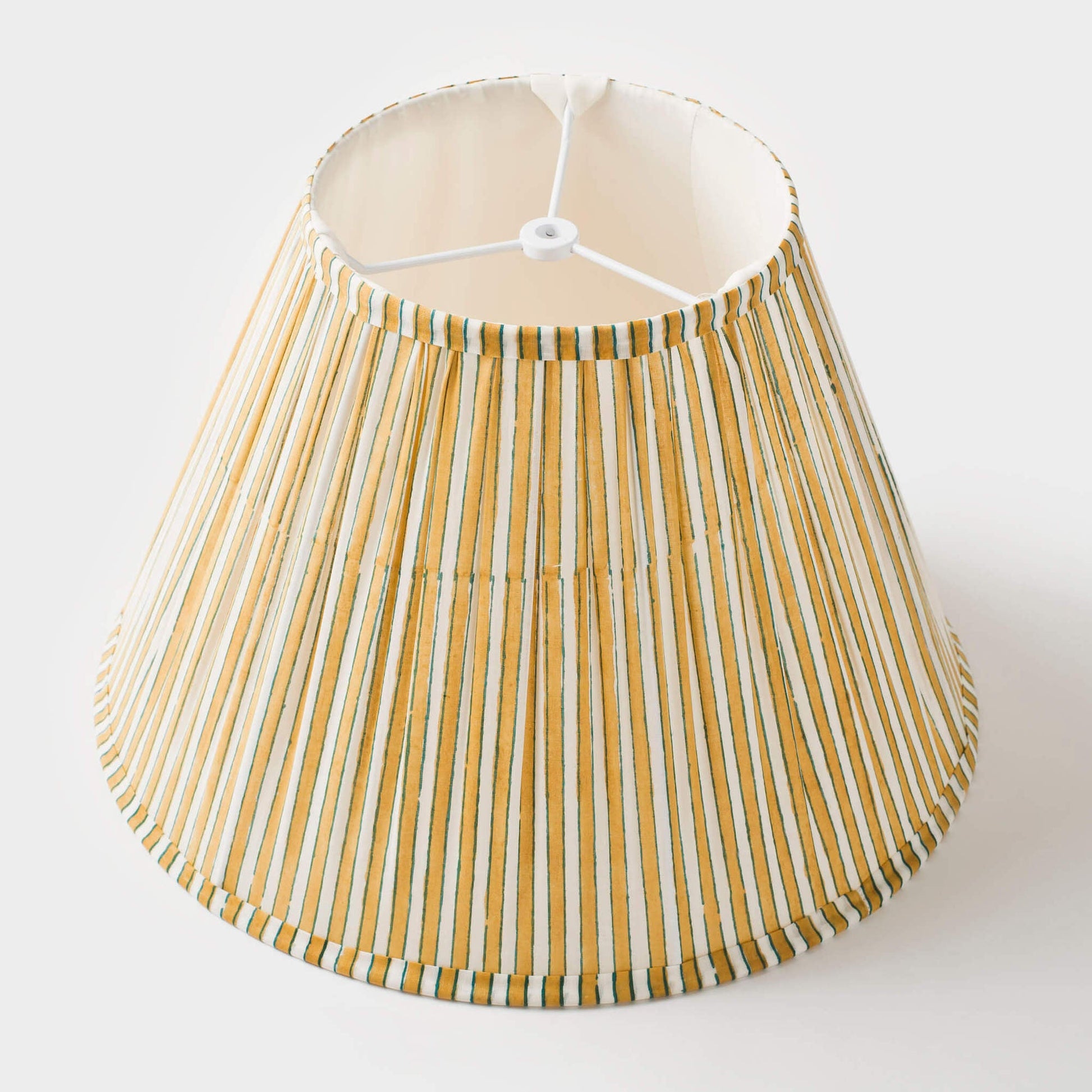 Interior view of the lamp shade showing the white frame and pleated fabric construction.