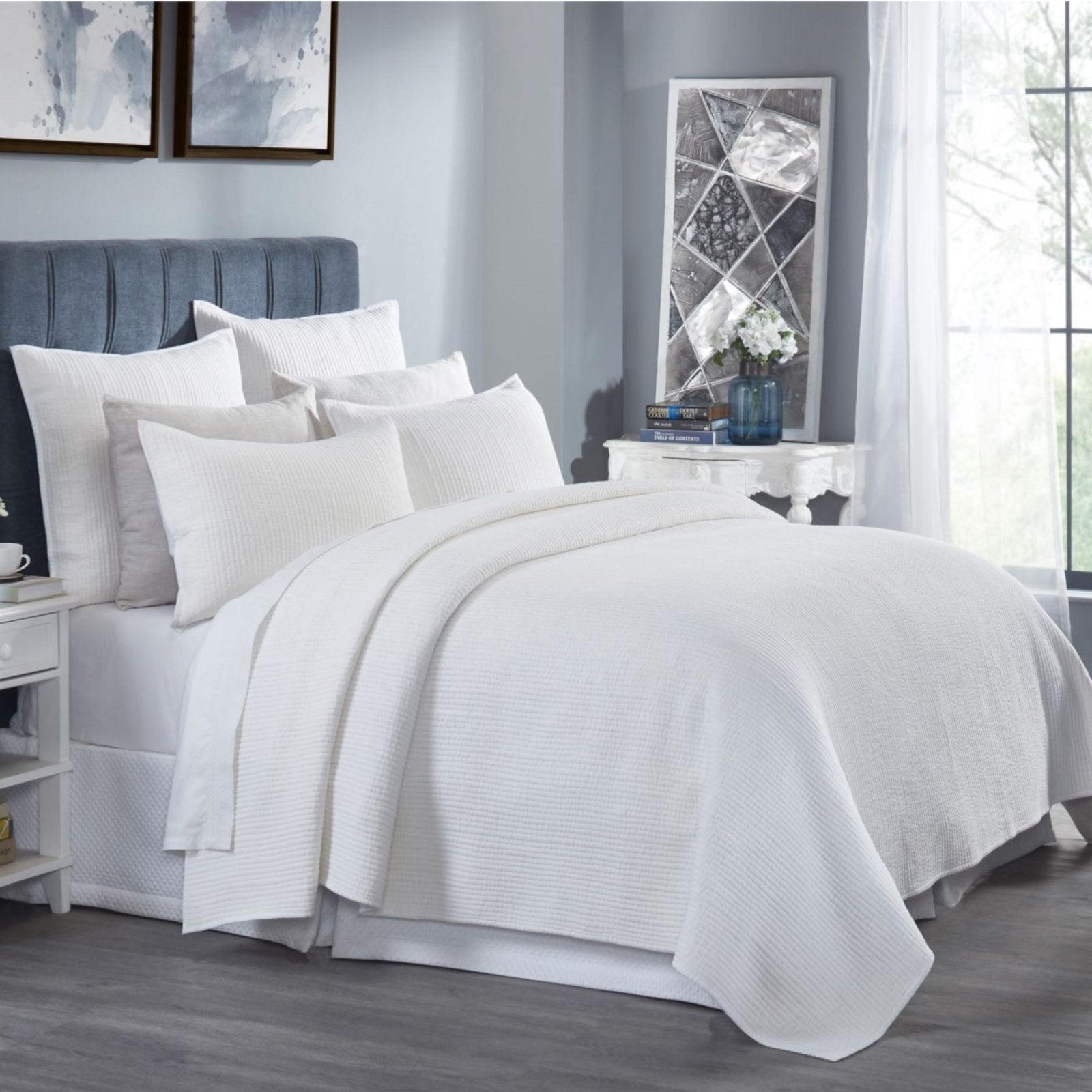 CL-196-9496_5|Elegant white channel stitch quilted coverlet draping a stylish bed, enhancing a bright bedroom with cozy texture.