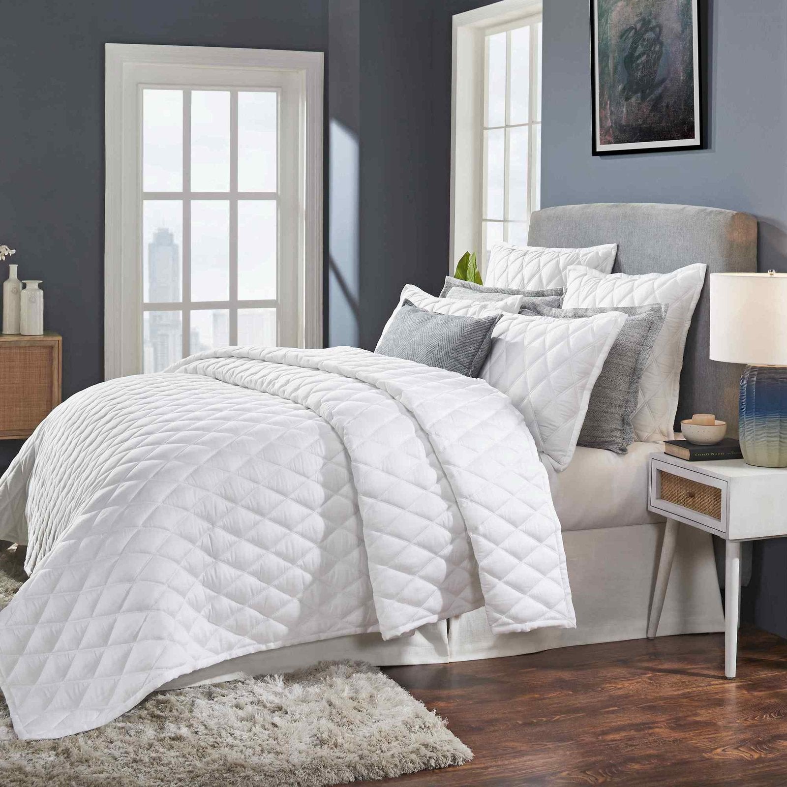 CL-179-X_2|Stylish white diamond quilted comforter and decorative pillows adorning a bed in a chic, contemporary room.