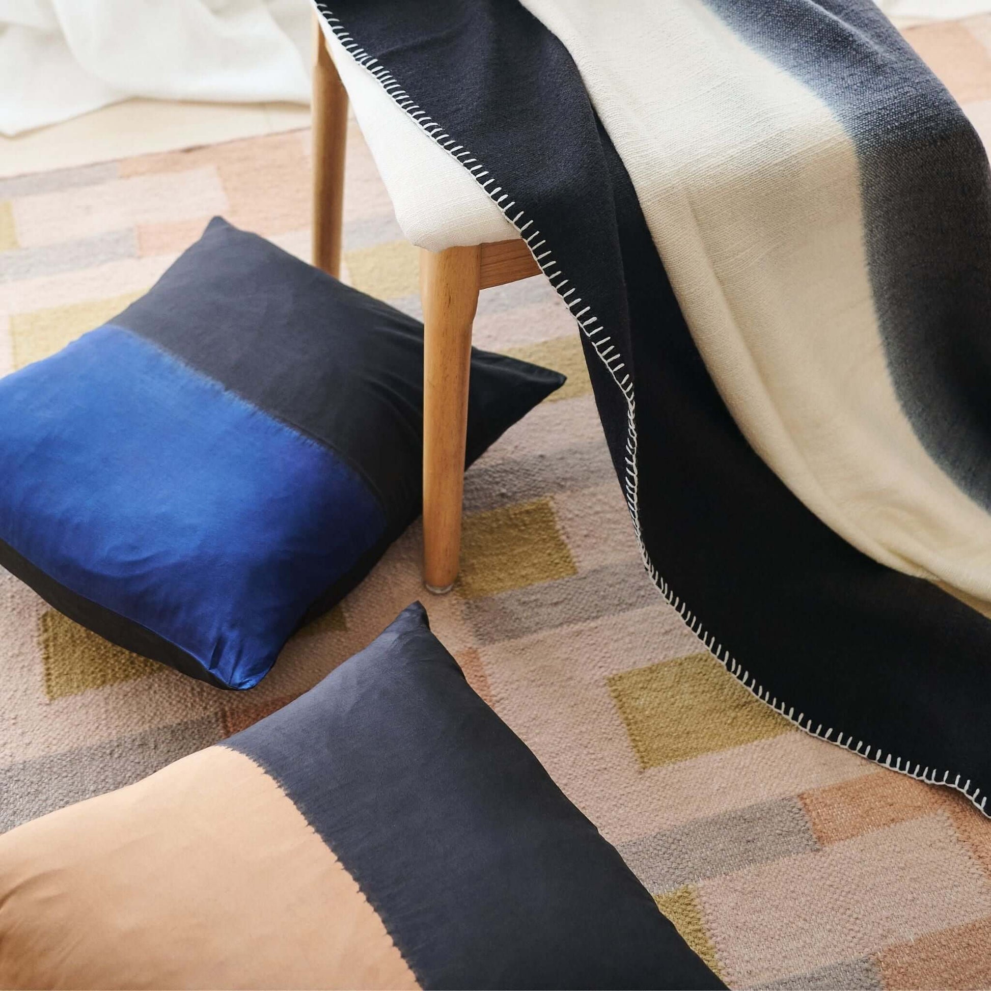 Ink Black White Ombre Textured Throw  In Hand Spun Merino And Hand Stitched Hem displayed with decorative pillows.