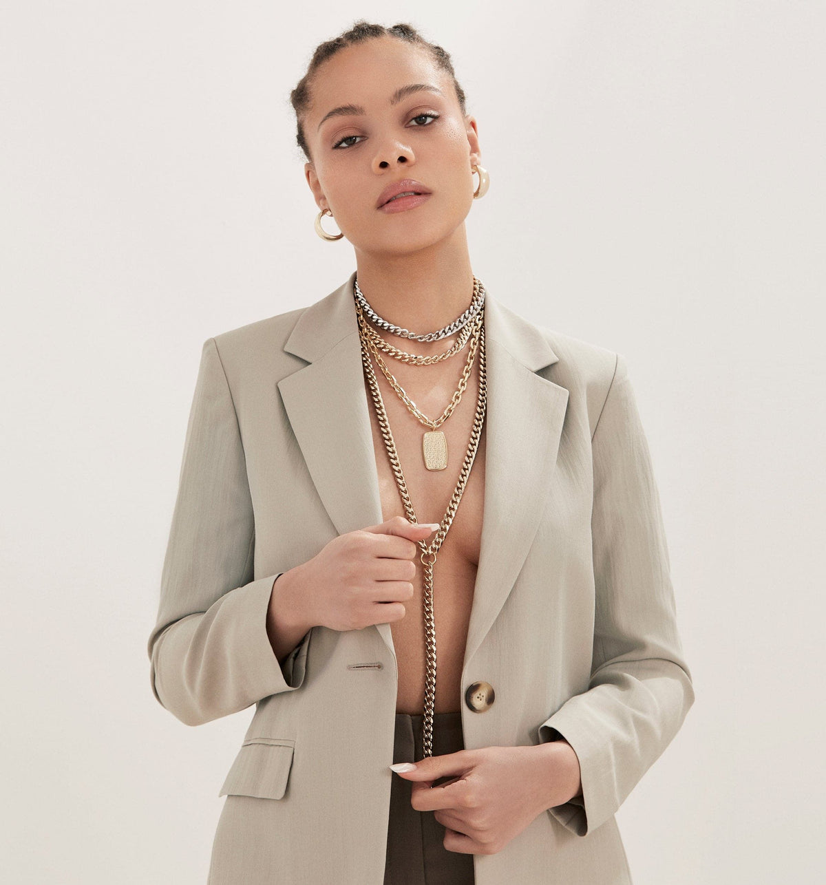 Woman in blazer sporting layered necklaces featuring the Lennon Necklace accessory