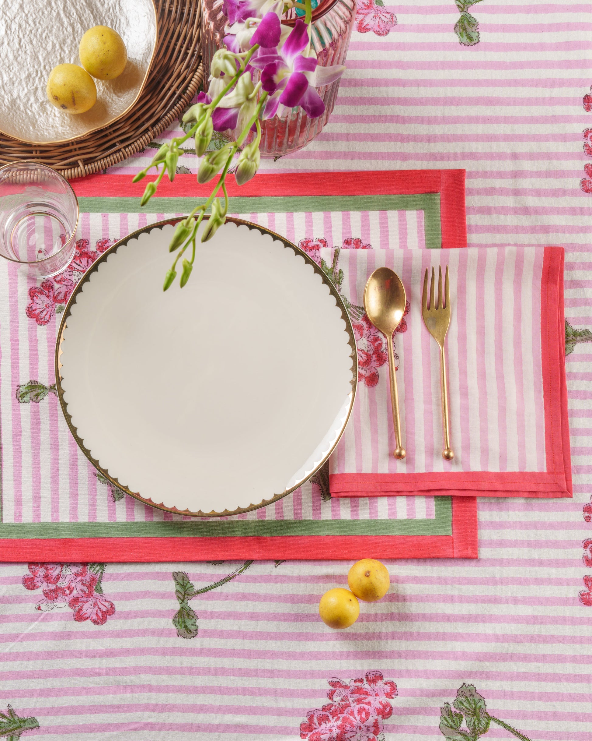 Pink hydrangea blockprint placemat in place setting with gold dishware