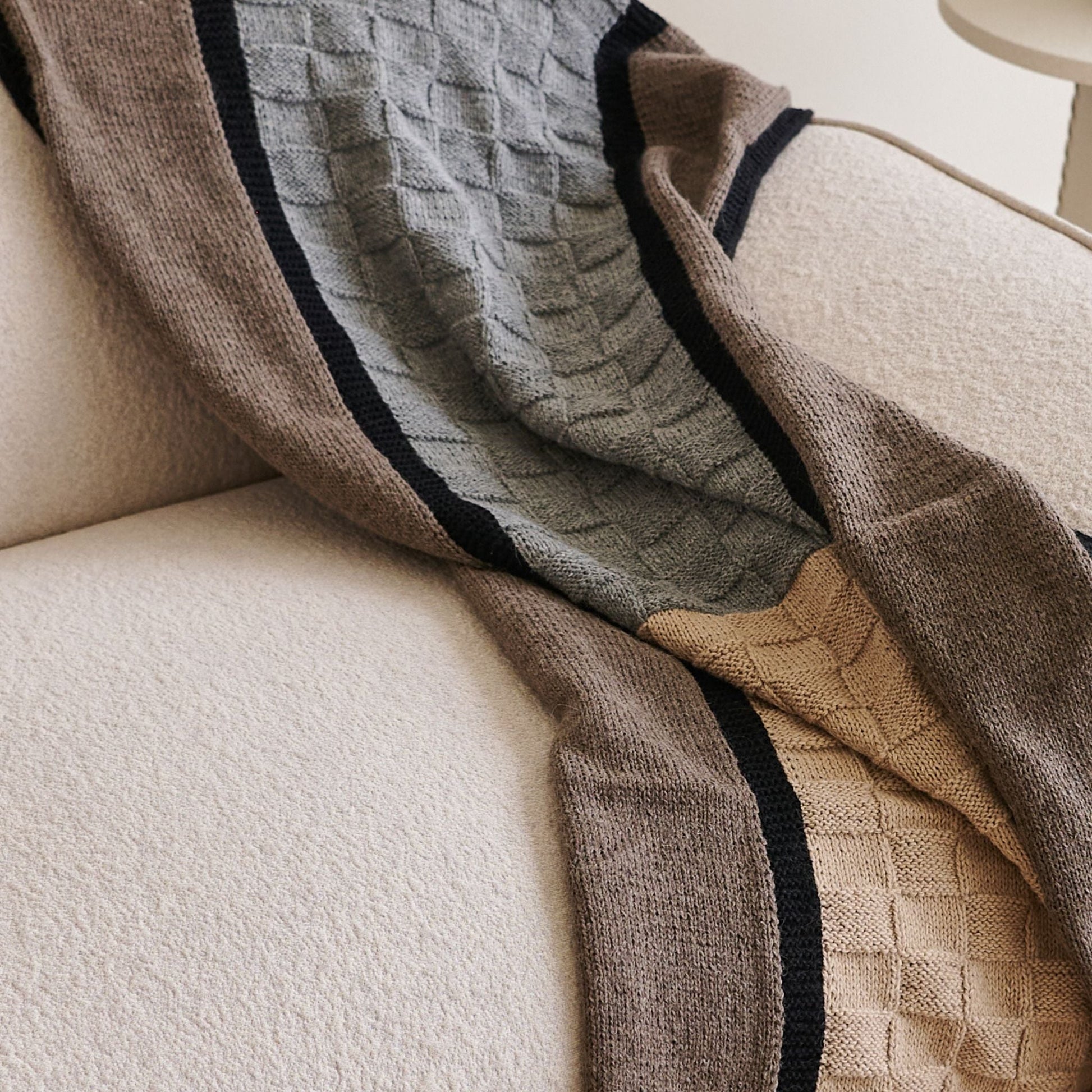 Muhu Brown Gray Hand Knitted Peruvian Alpaca Blanket / Large Plush Scarf draped elegantly on a sofa.