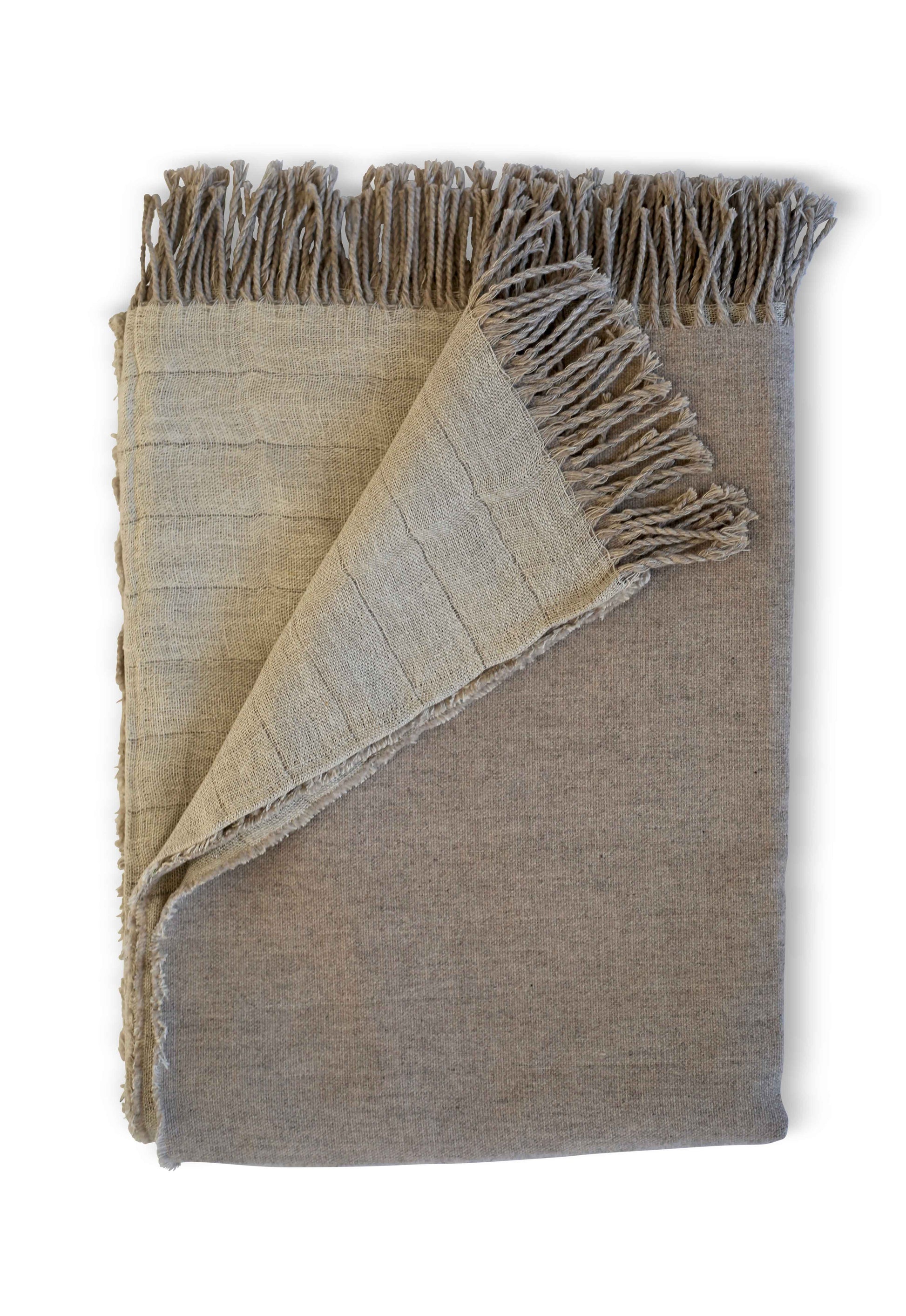 Elevate your comfort with this luxurious Evangeline Linens throw blanket. Crafted from the finest linen and merino wool, it showcases fringes and a reversible design. A true symbol of luxury.