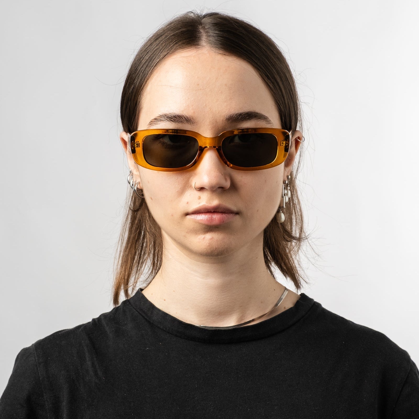 Female wearing Sad Eyewear Bouquet rectangle sunglasses in amber with UV protection lenses