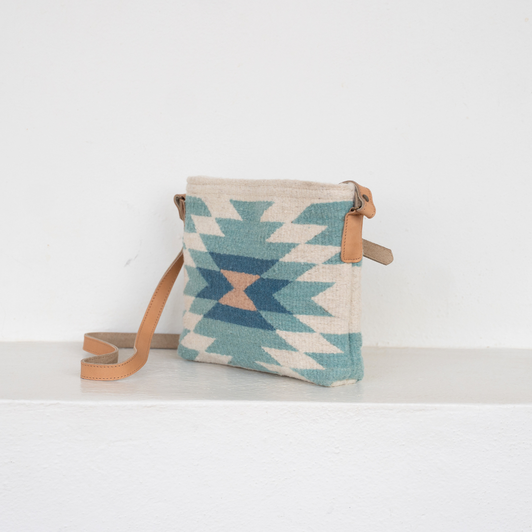Handwoven crossbody bag with abstract Zapotec diamond design in soft spring tones; features adjustable leather strap and two internal pockets for daily essentials