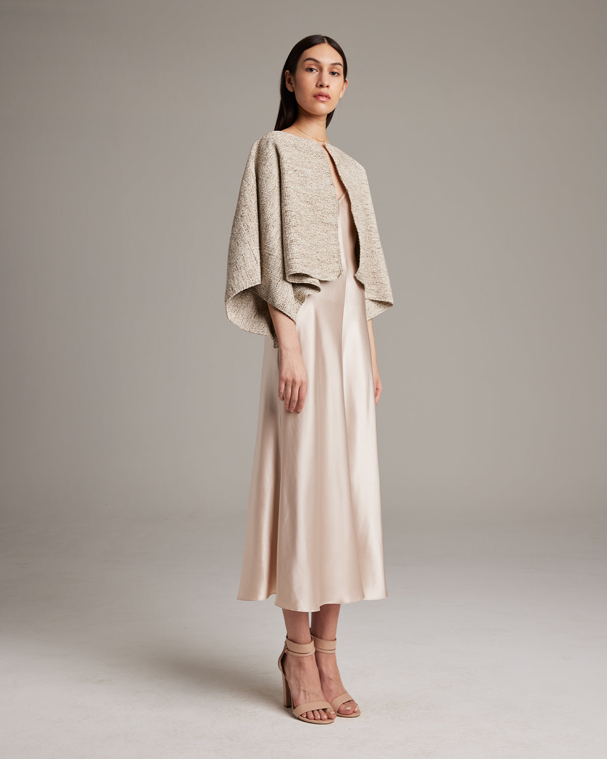 Model wearing a hand-loomed Marble Bolero over a satin dress