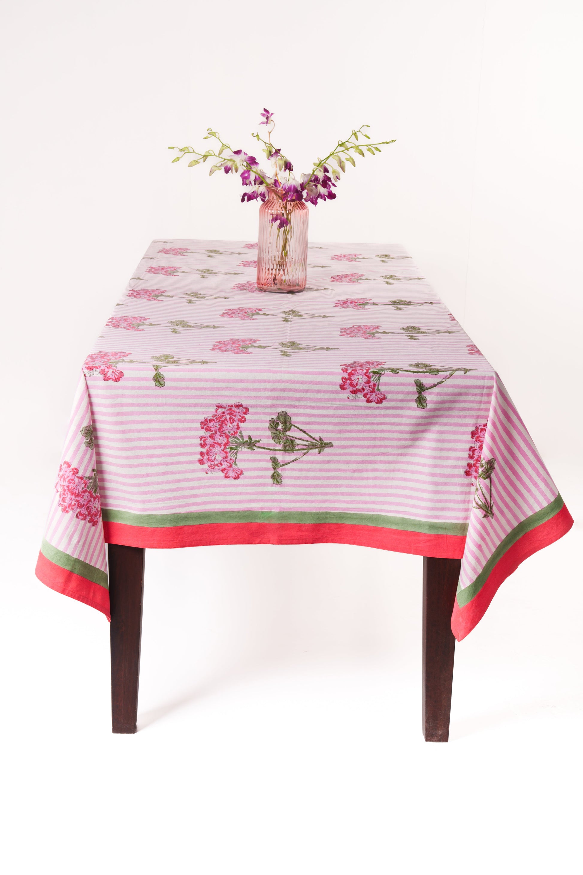 Pink hydrangea blockprint tablecloth draped over wooden table