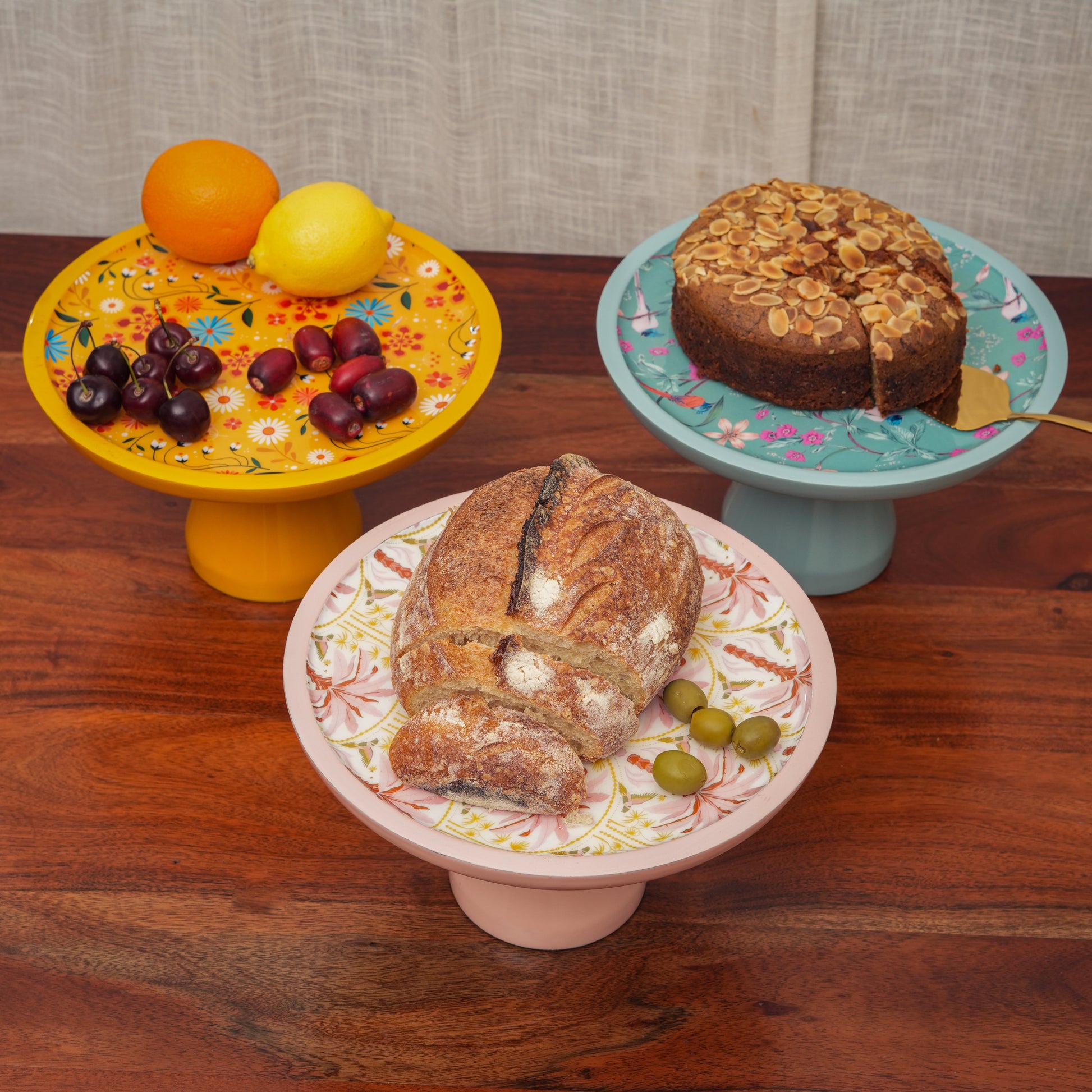High-angle view of a turquoise cake stand featuring pink and orange floral patterns.