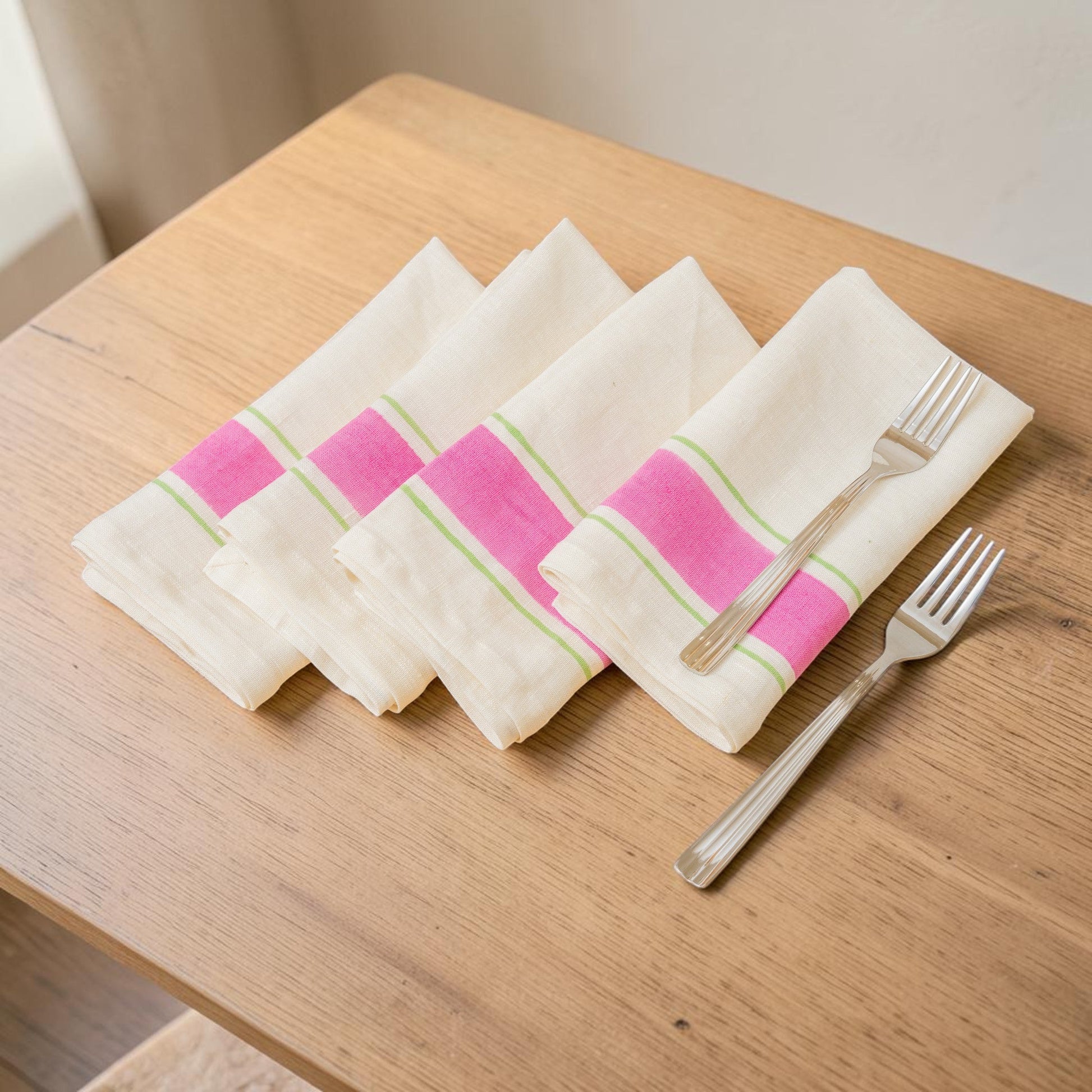Set of 4 hand printed linen napkins in pink and green  laid out on the wooden table