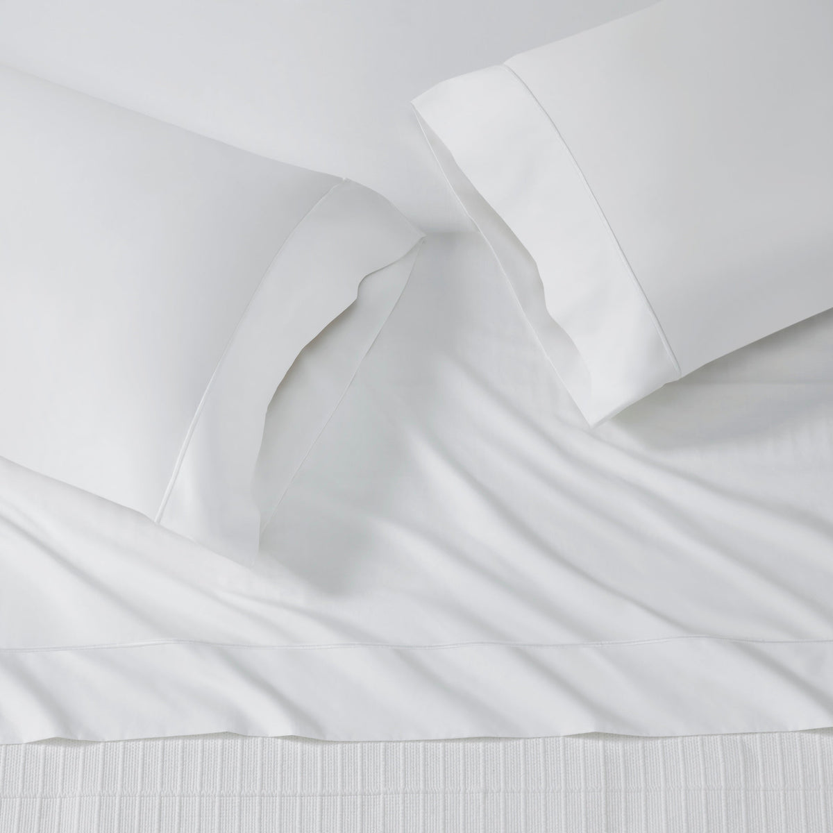 ASP-533-2032_3|Plain white 100% cotton flat sheet and two matching pillowcases on a bed, all with a crisp, clean appearance.
