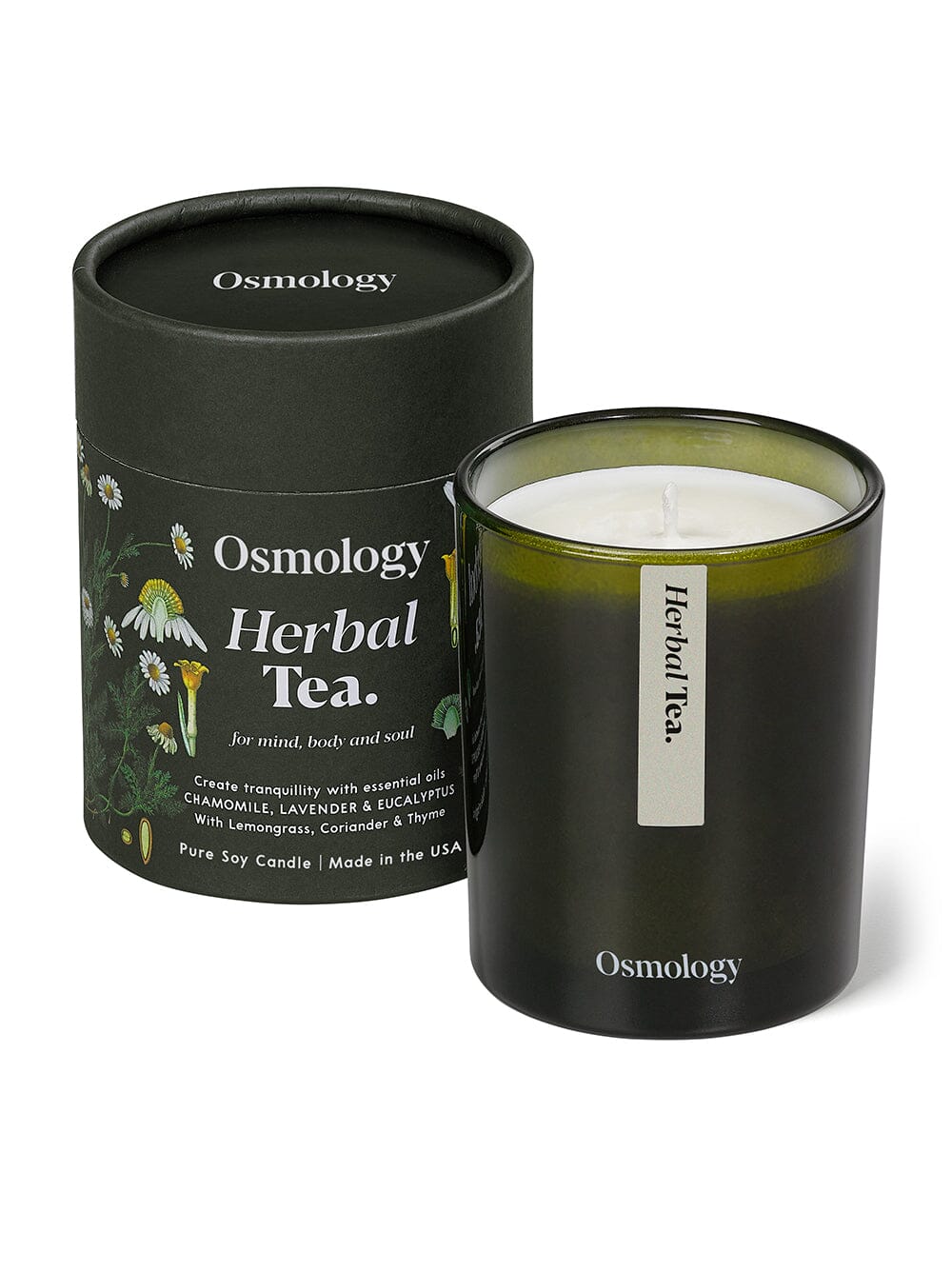 Osmology Herbal Tea candle displayed on cube behind product packaging tube on yellow cream background