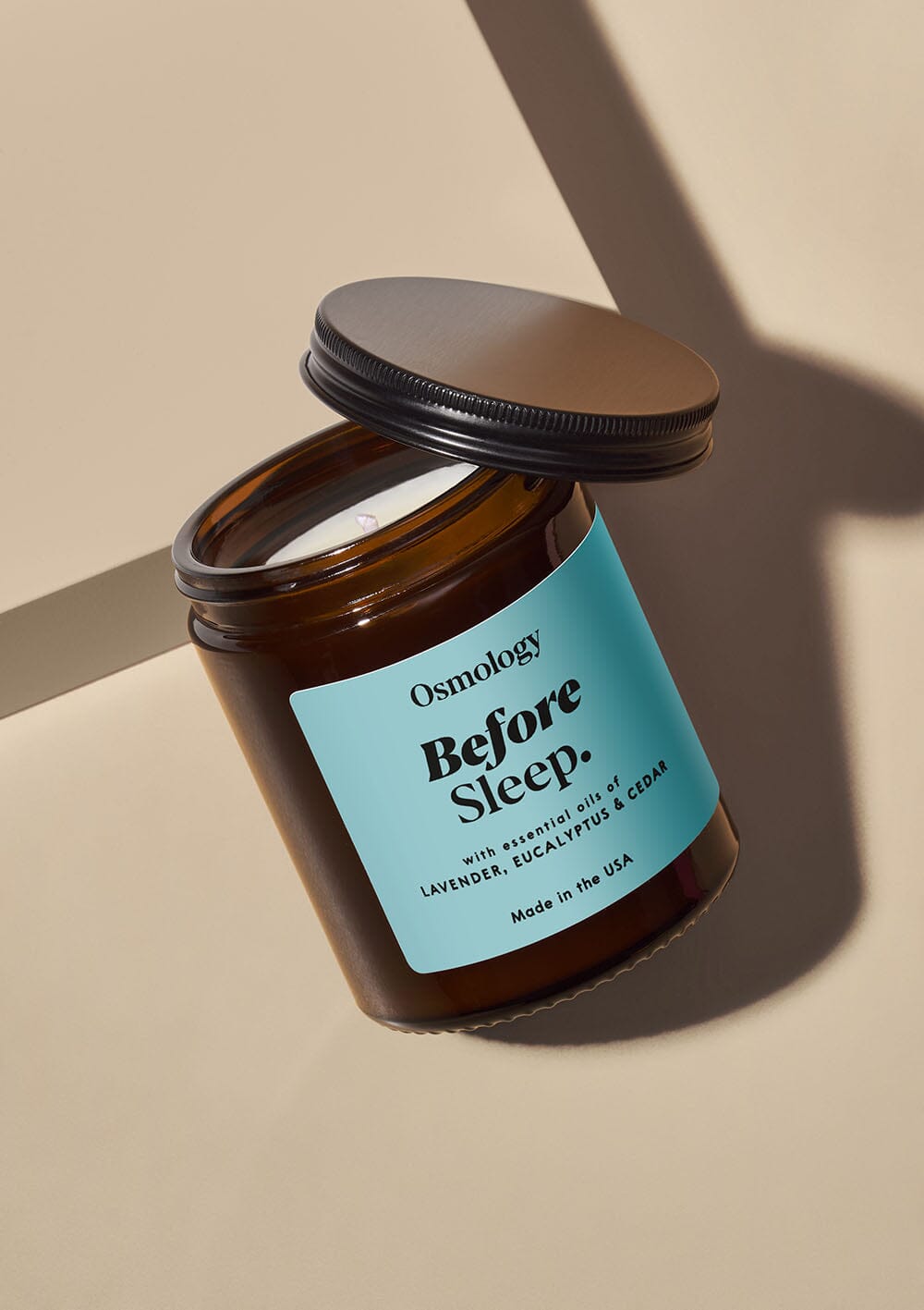 Osmology Before Sleep jar candle, a brown glass jar with light blue sticker and black lid 