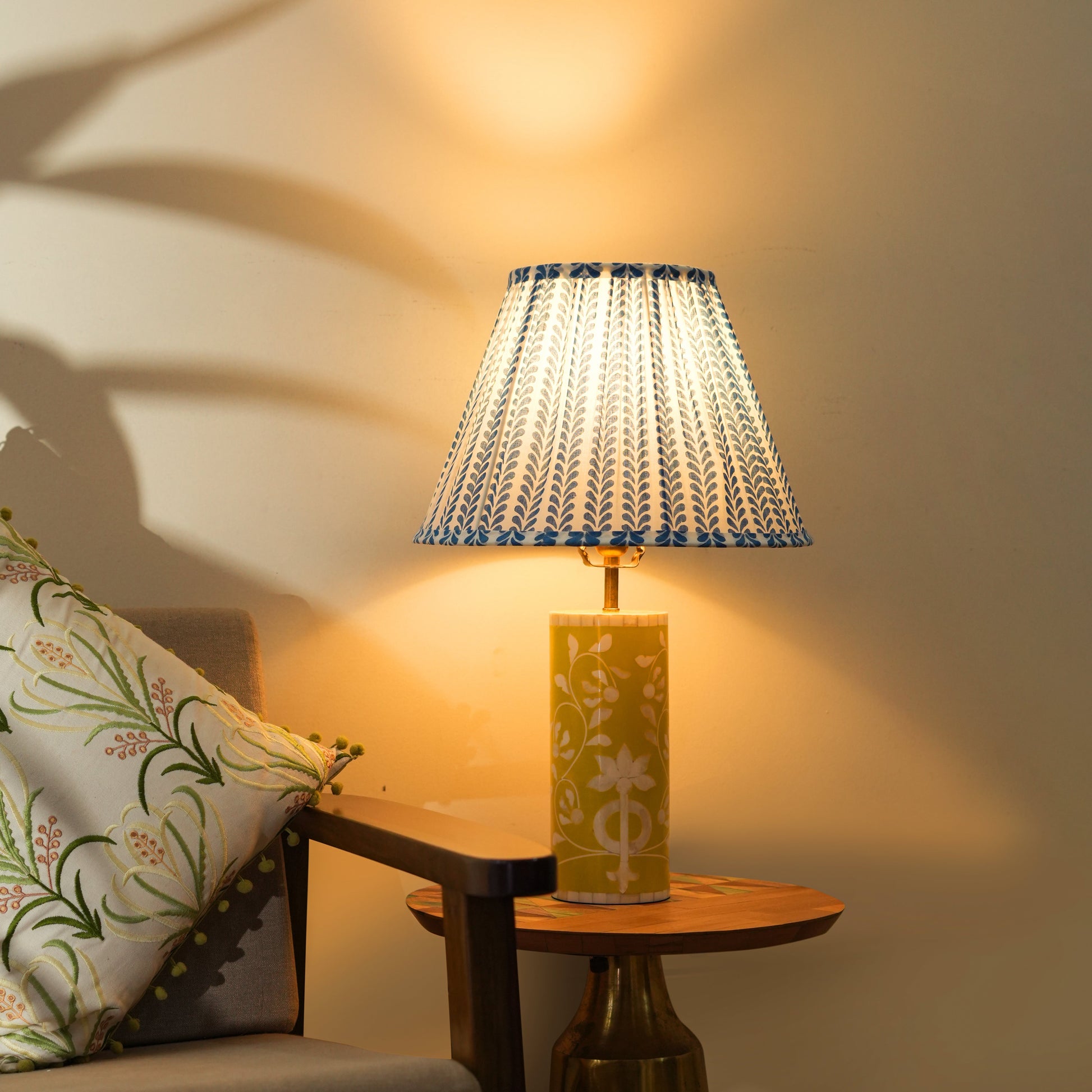 Decorative lamp on a side table with a patterned shade in a warm indoor setting.