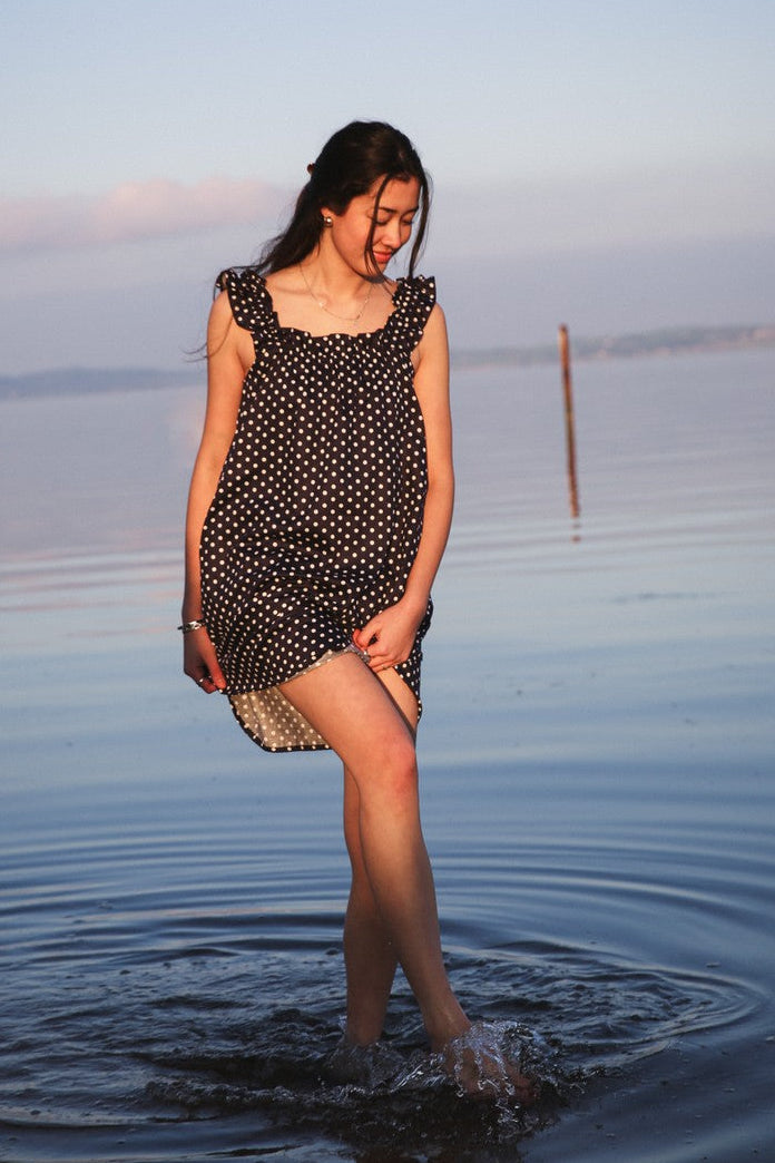 Mila Navy dress in motion at the waterline, retouched